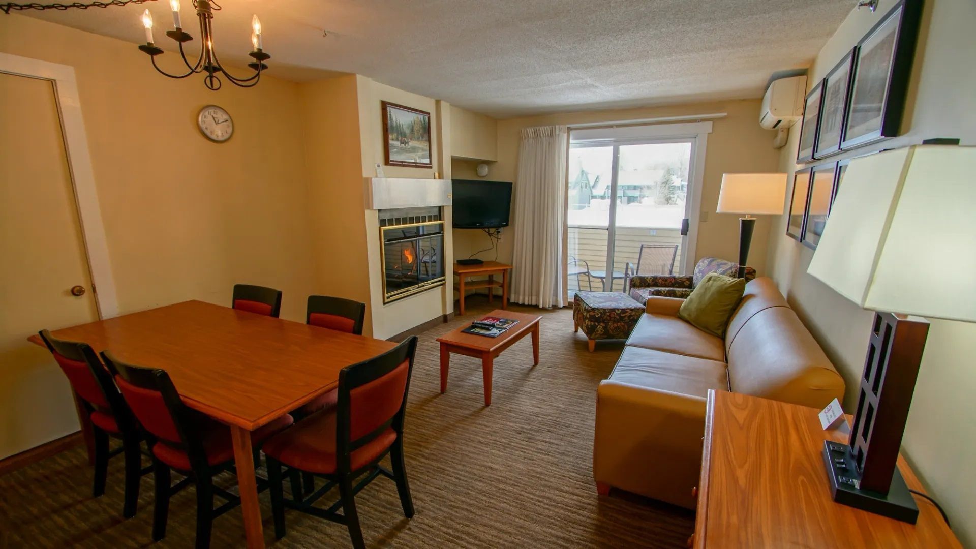 image Unwind in a cozy living area featuring a fireplace, dining space, and a sofa sleeper, this room offers everything you need for a comfortable getaway, with easy access to scenic outdoor mountain views.