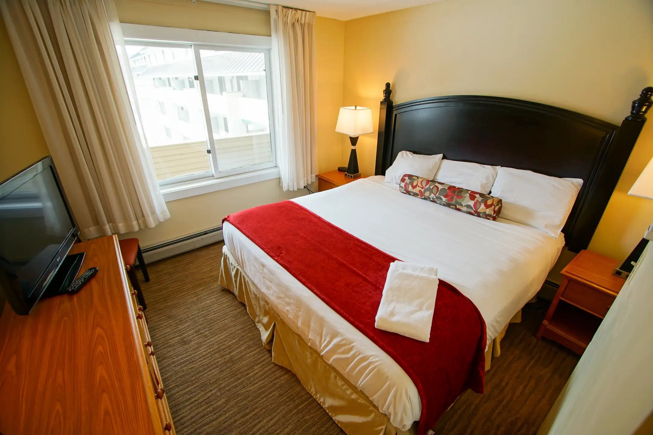 image Retreat to a beautifully appointed master bedroom, complete with a plush king bed and modern amenities, ensuring a restful night in the heart of nature's beauty at Loon Mountain.