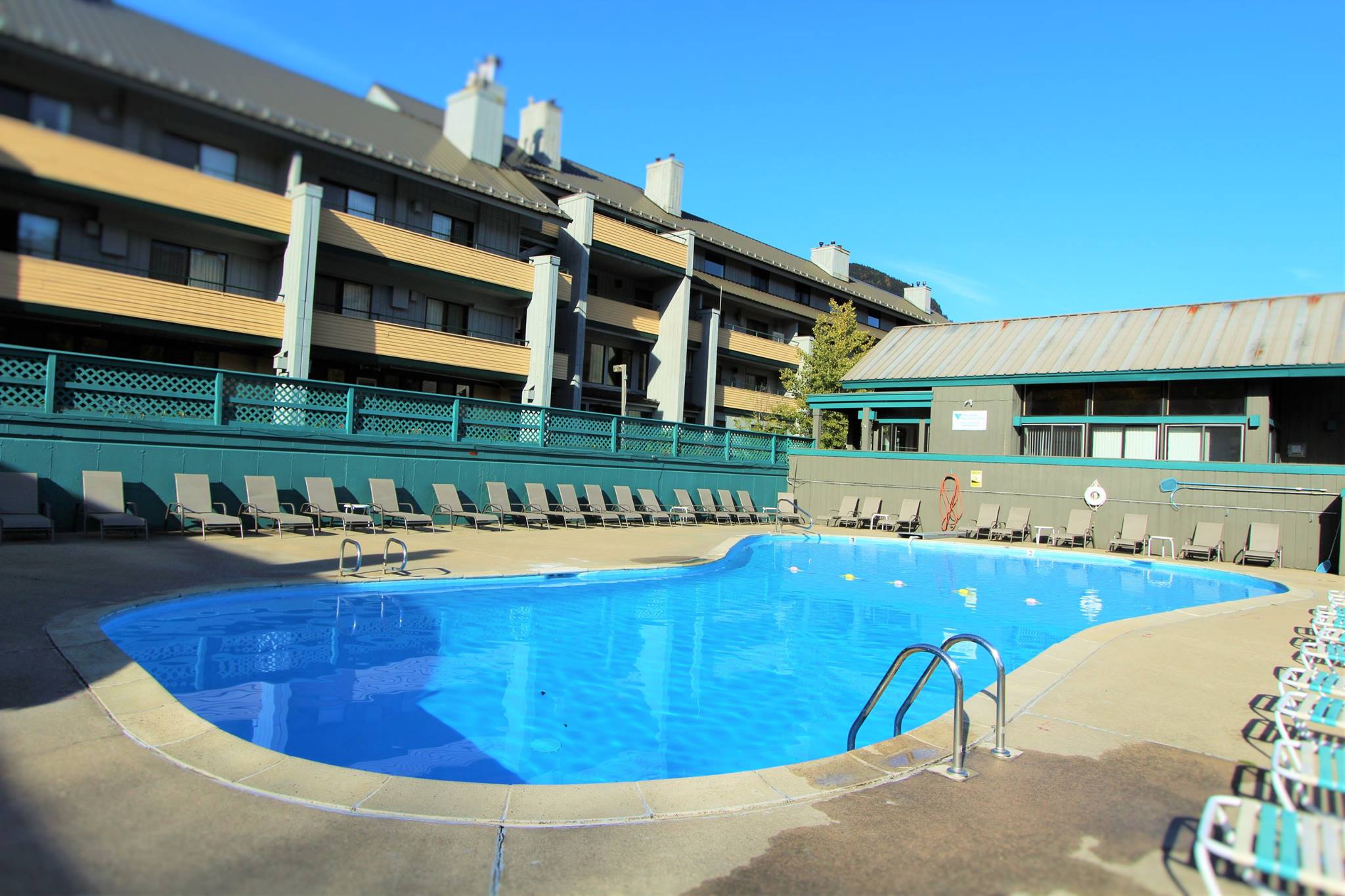 image Lounge by the outdoor pool with ample sun deck space, ideal for soaking up rays while enjoying majestic mountain views.