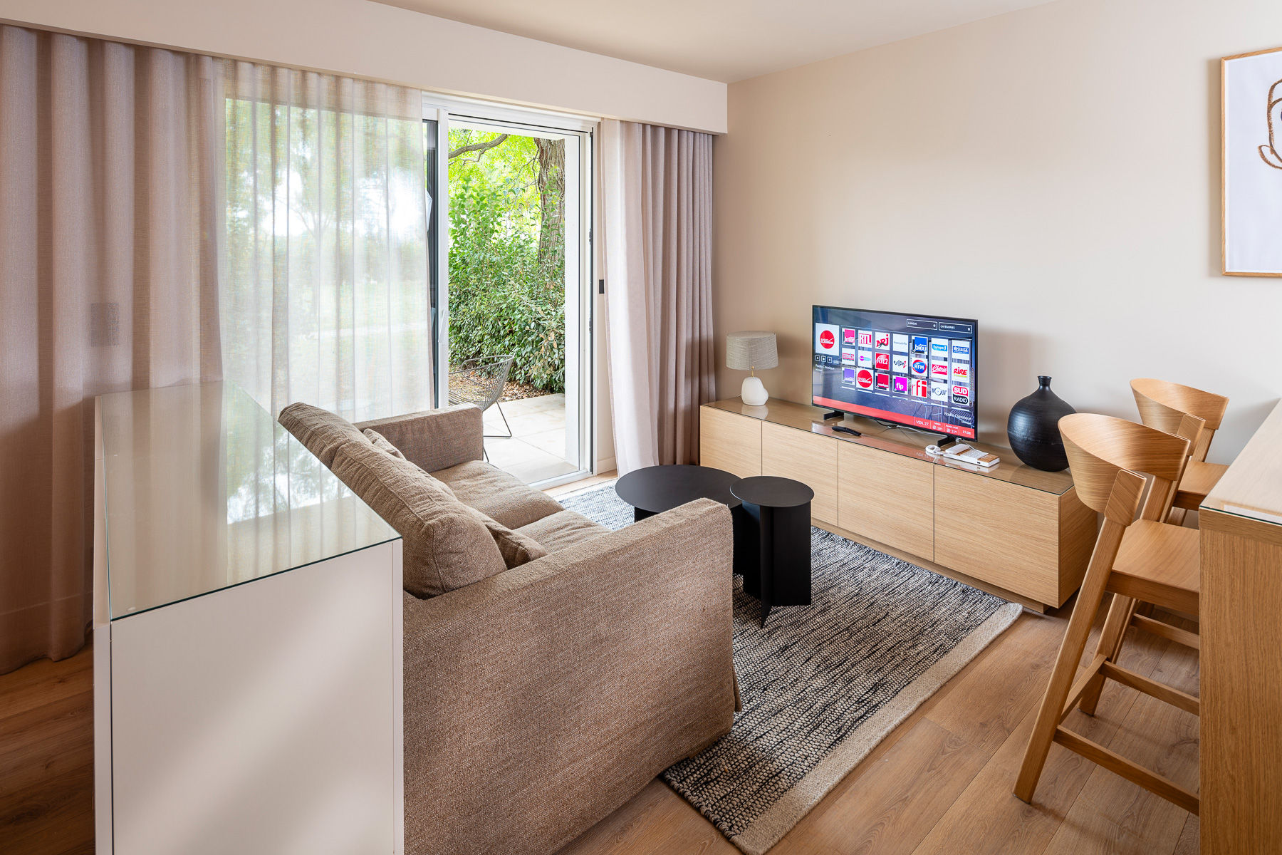 image Bright living space with large windows and soft seating—perfect for a relaxing evening or streaming your favorite shows.