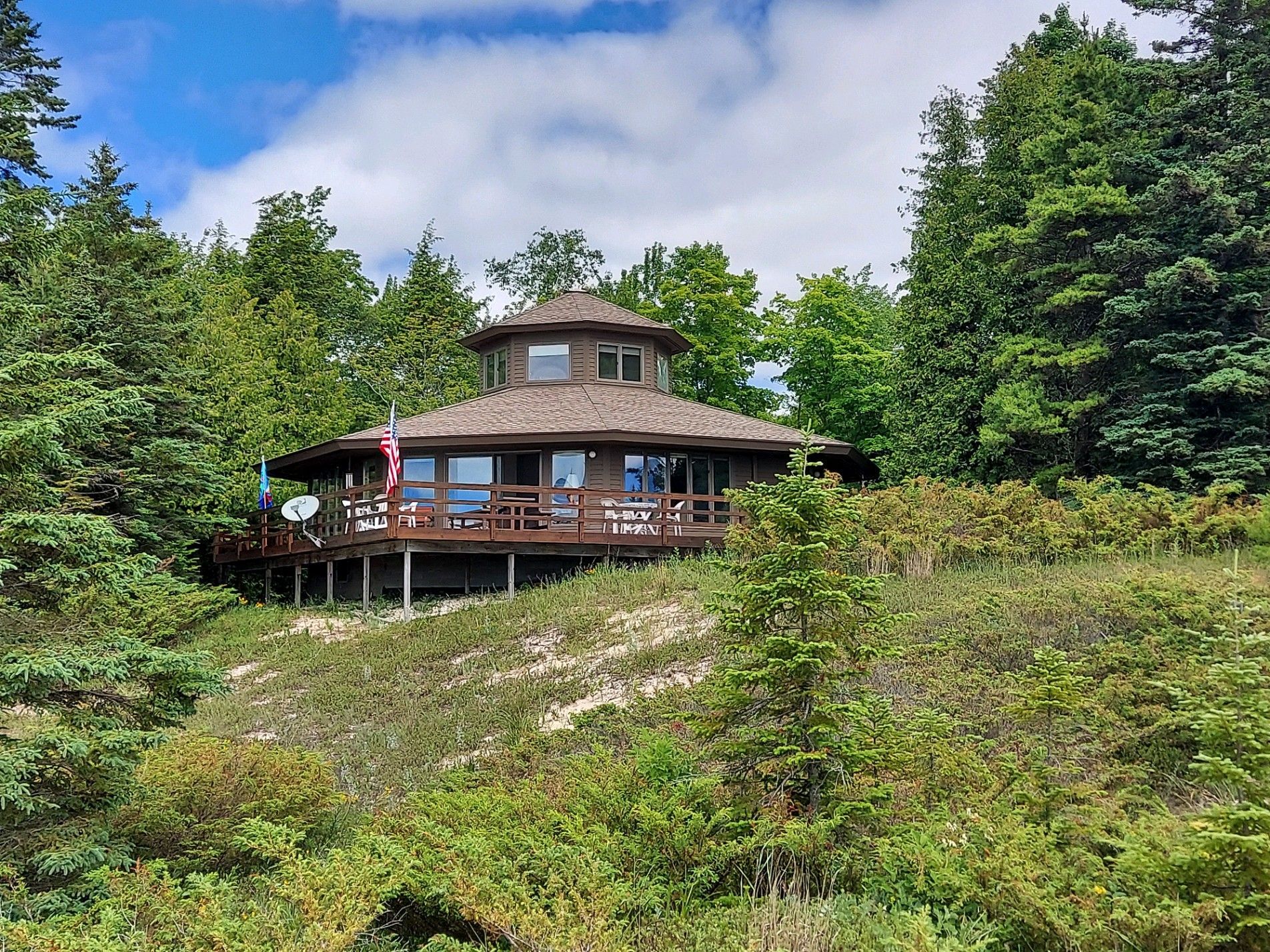 image Custom octagon home perched above the dunes, offering panoramic views of Lake Michigan and total privacy on 12 wooded acres.