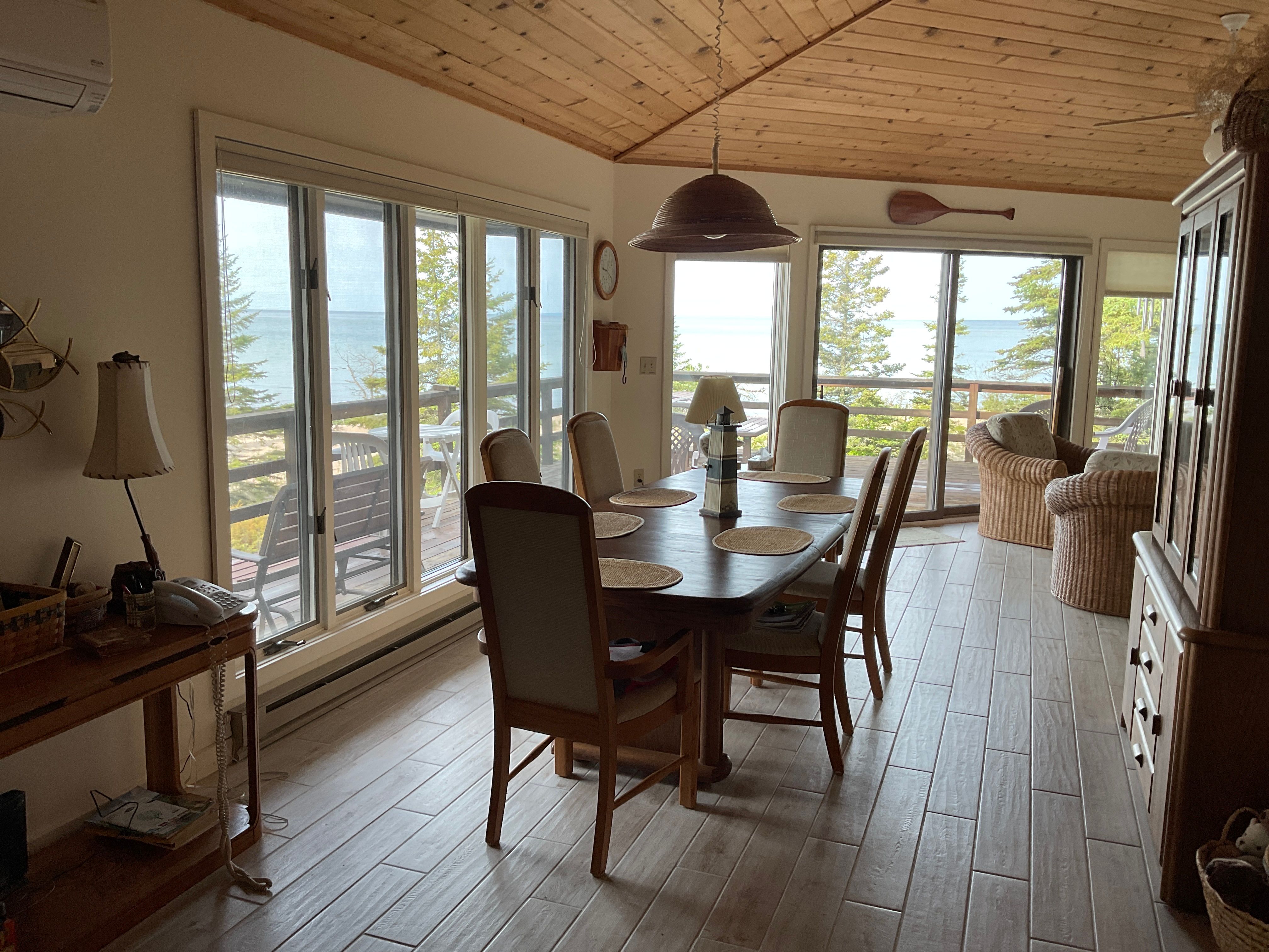 image Dining area with large windows and vaulted ceilings, blending indoor comfort with outdoor beauty.