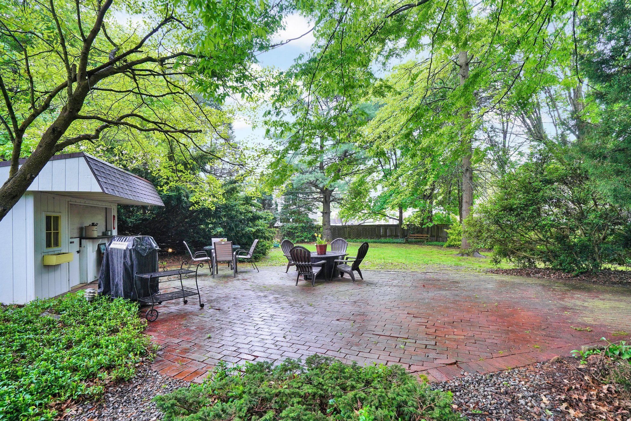 image Spacious backyard with a paved patio—perfect for outdoor dining, games, or simply unwinding under the trees.