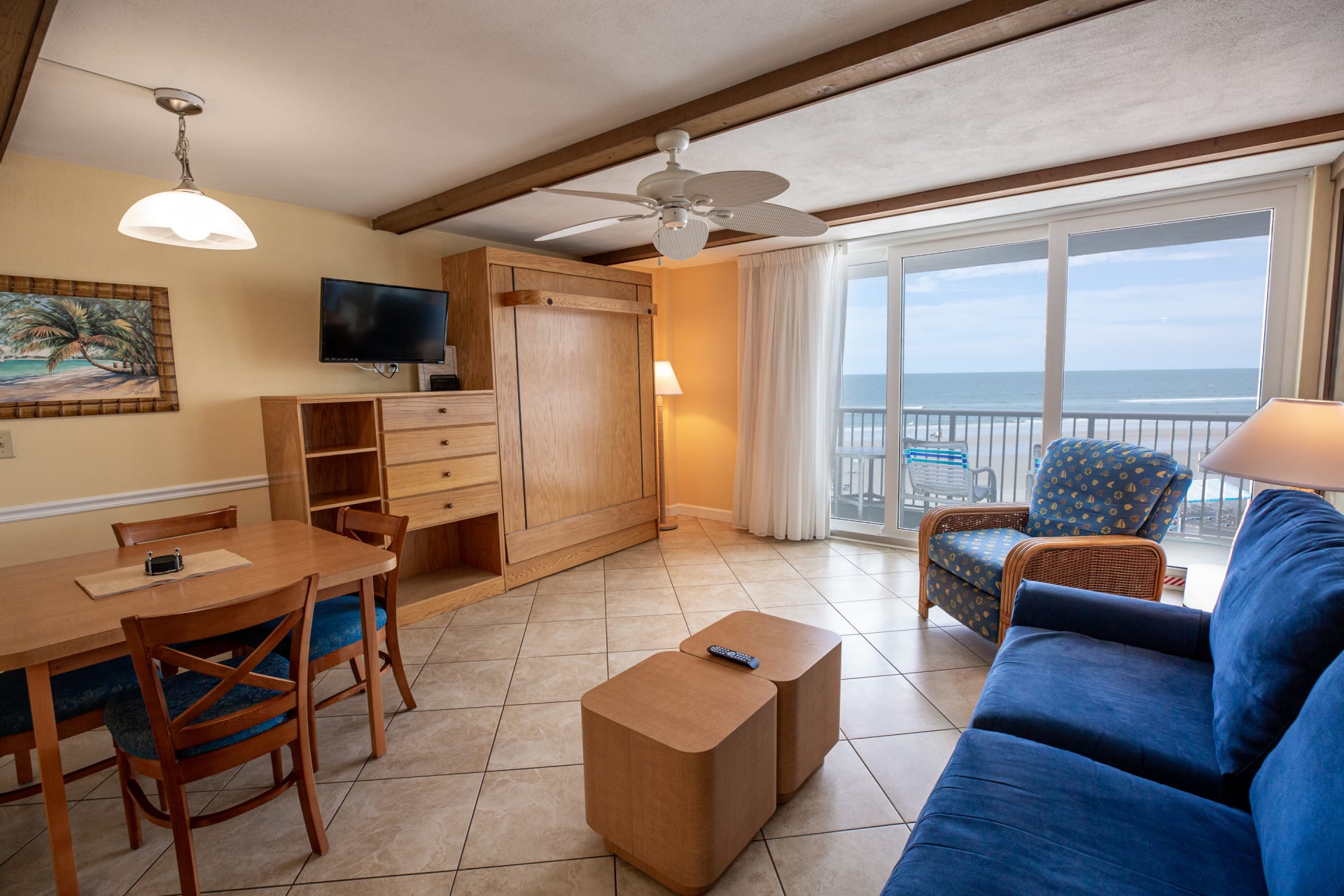 image This inviting oceanfront studio features a cozy living area with a queen Murphy bed, a comfortable sofa bed, and a charming dining space, all bathed in natural light from the sliding doors leading to the private balcony.