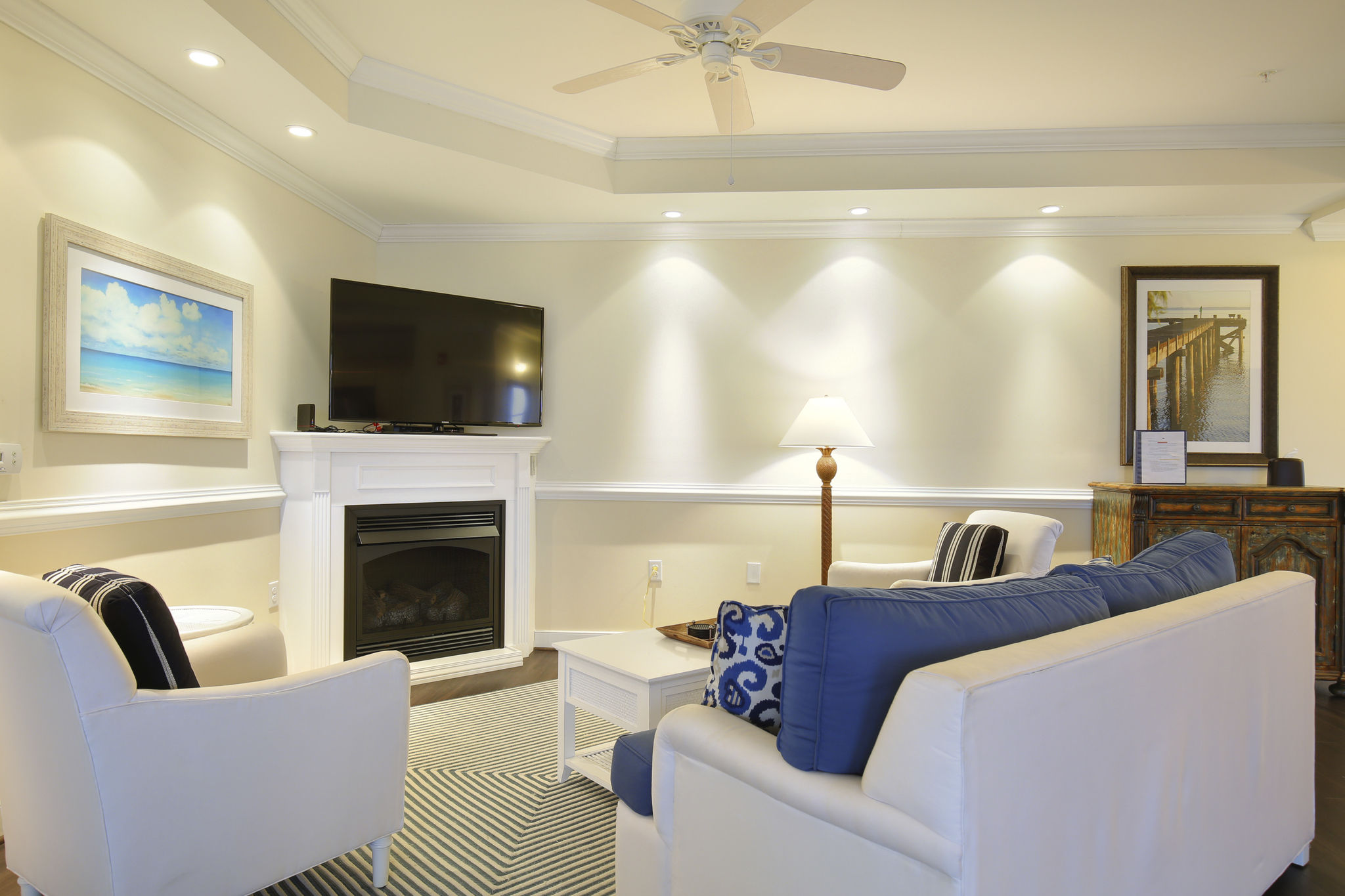 image Living room with seating, TV, fireplace, and decorative lamps.