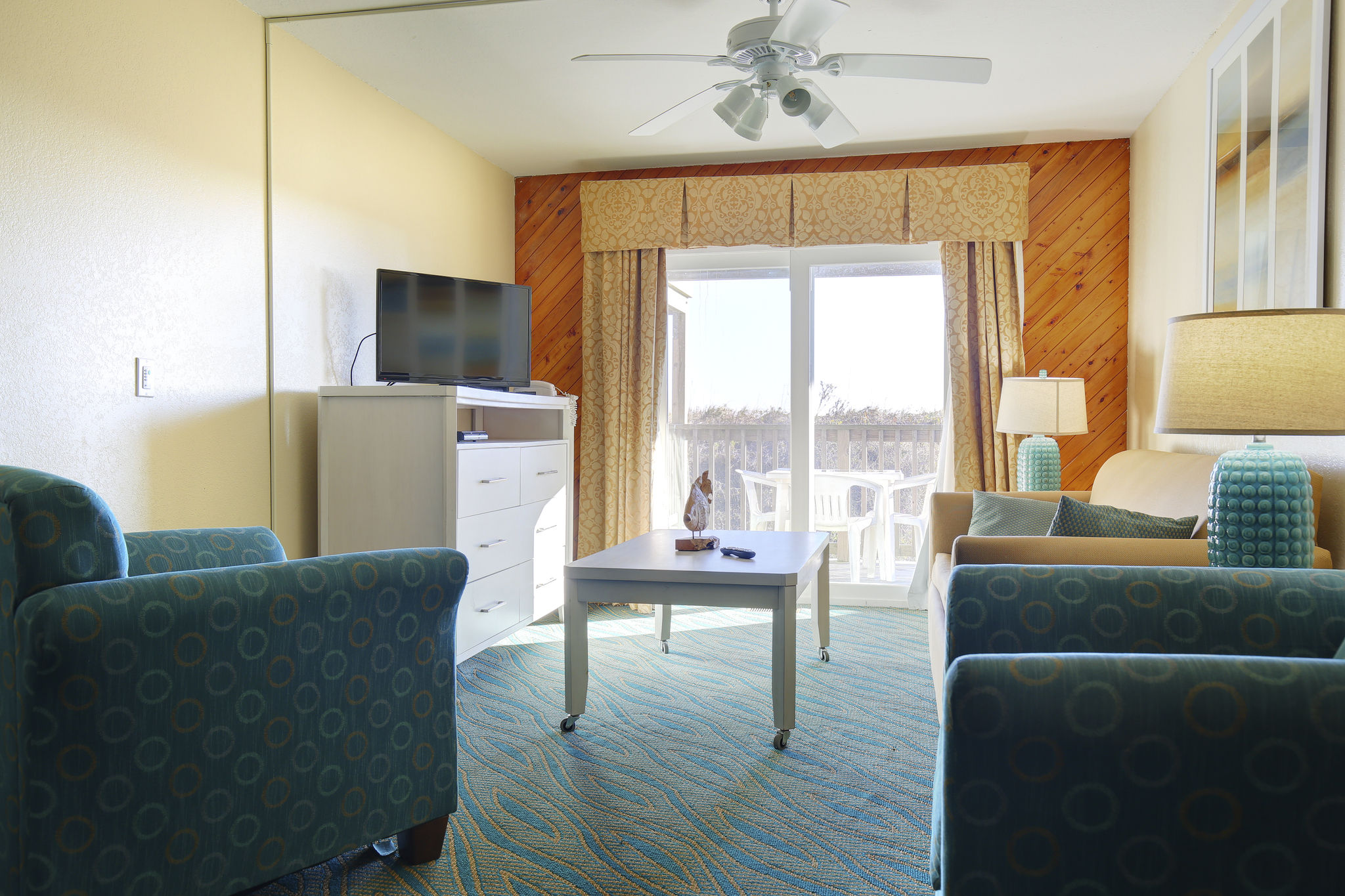 image Inside, the cozy living area is complete with comfortable furnishings and a flat-screen TV, perfect for relaxing after a day at the beach.