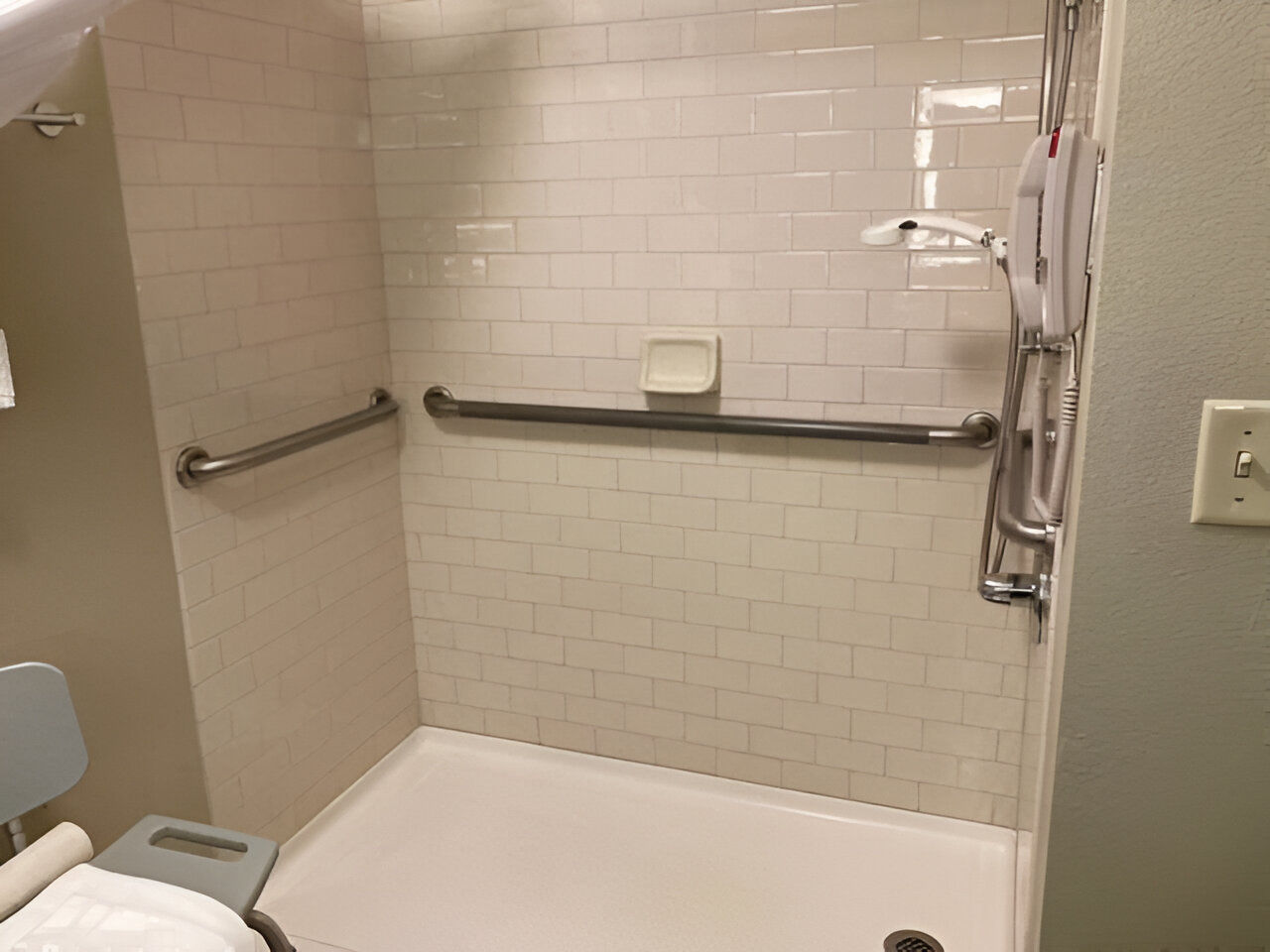image Clean lines and thoughtful enhancements make this roll-in shower a calming space for accessible self-care.