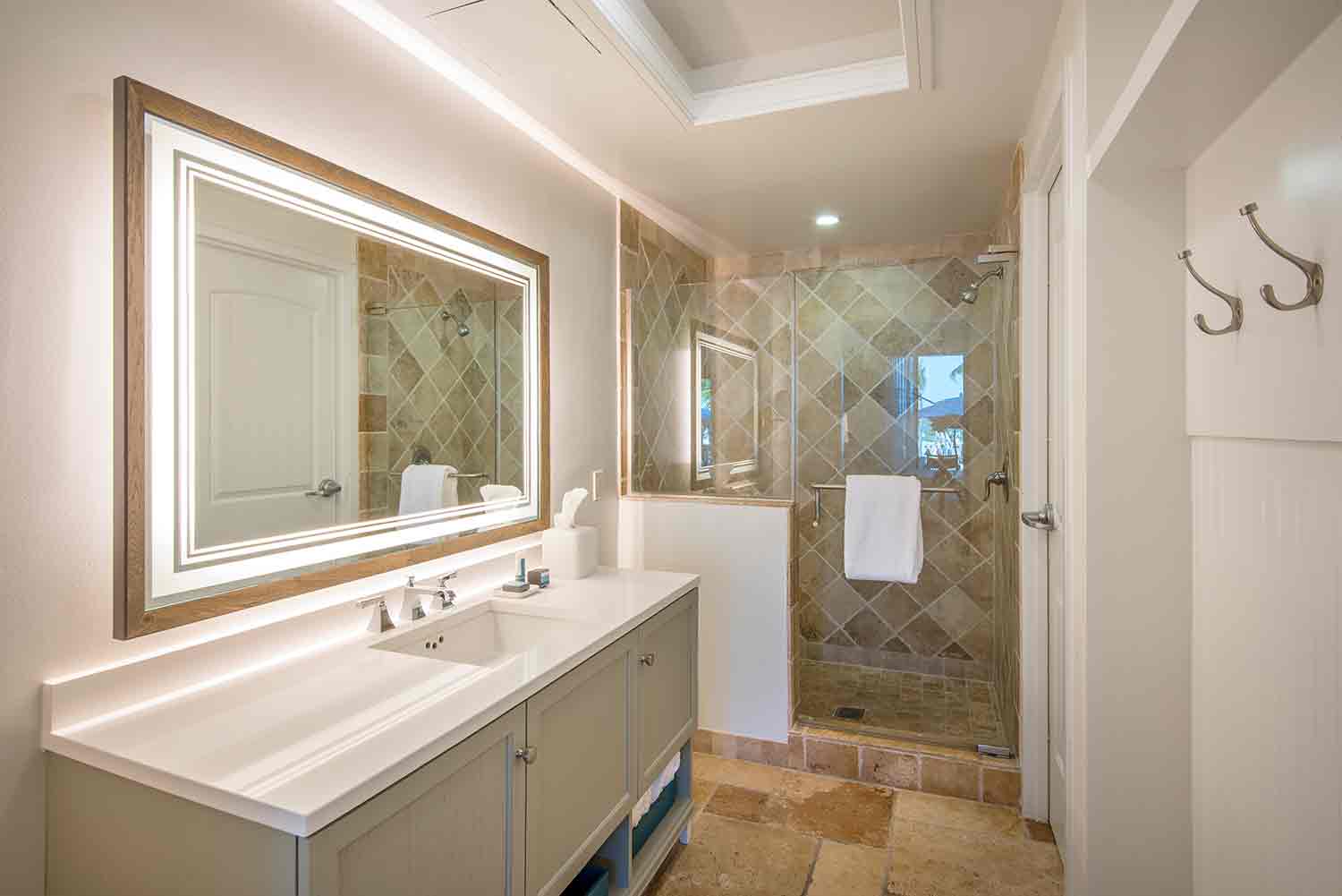 image Begin and end your day with ease in a refreshing bathroom retreat framed in soft lighting and natural stone.