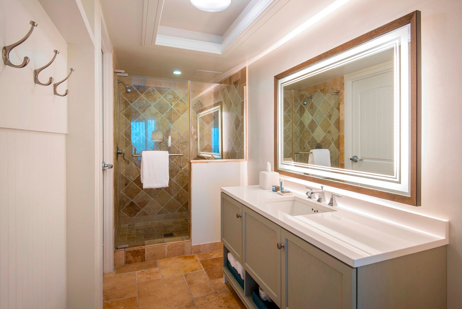 image Refresh with ease in a spa-like bath where glowing mirrors and earthy tilework bring warmth to your daily routine.