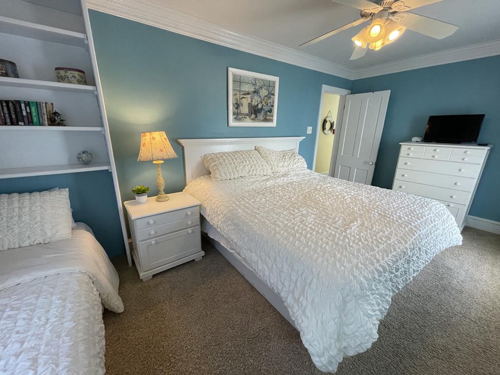 image This cozy bedroom features a plush king-sized bed alongside a twin bed, all set against a soothing blue wall that enhances the room's tranquil atmosphere.