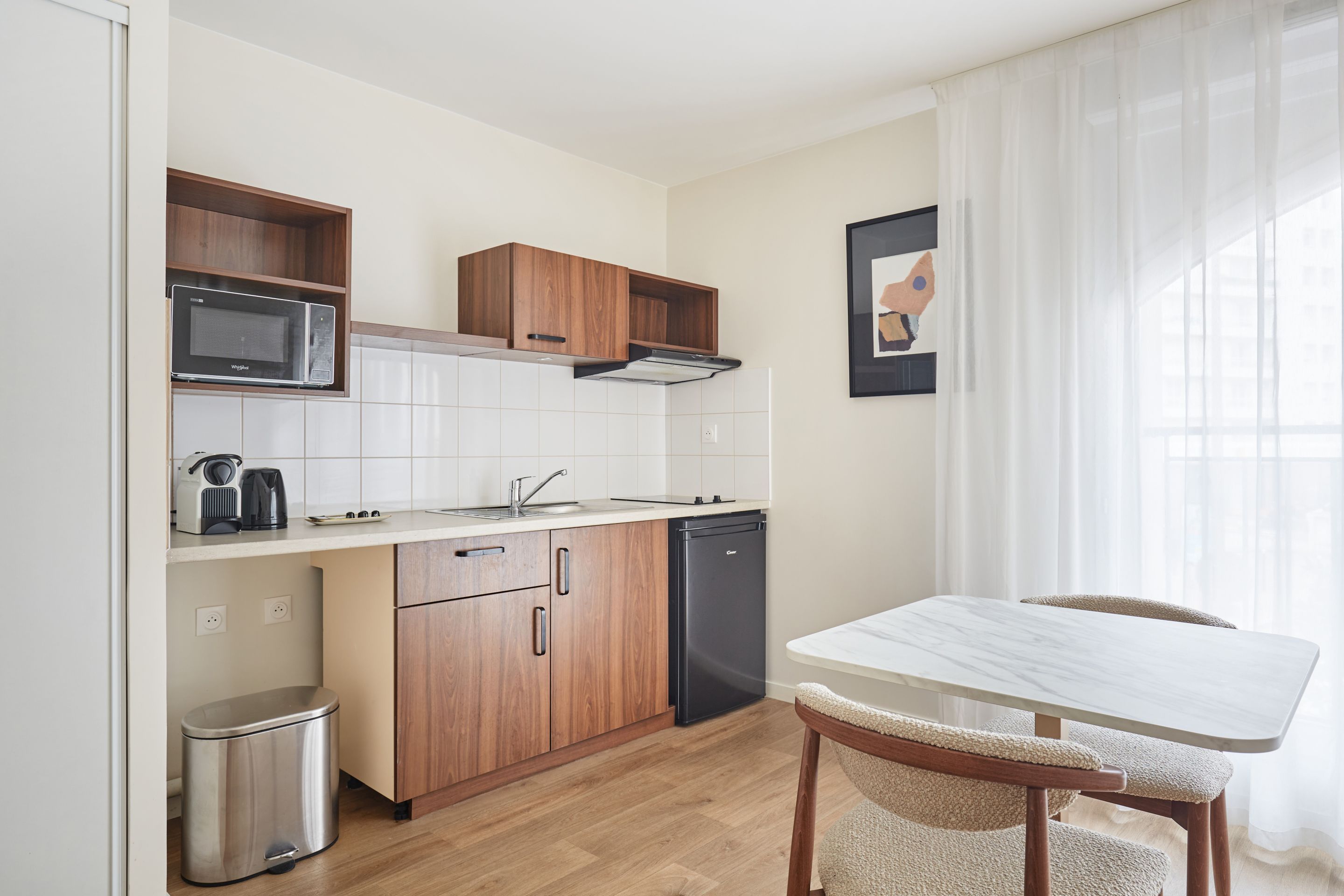 image Fully equipped kitchenette with induction hob, microwave, fridge, kettle, and coffee maker for easy at-home meals.