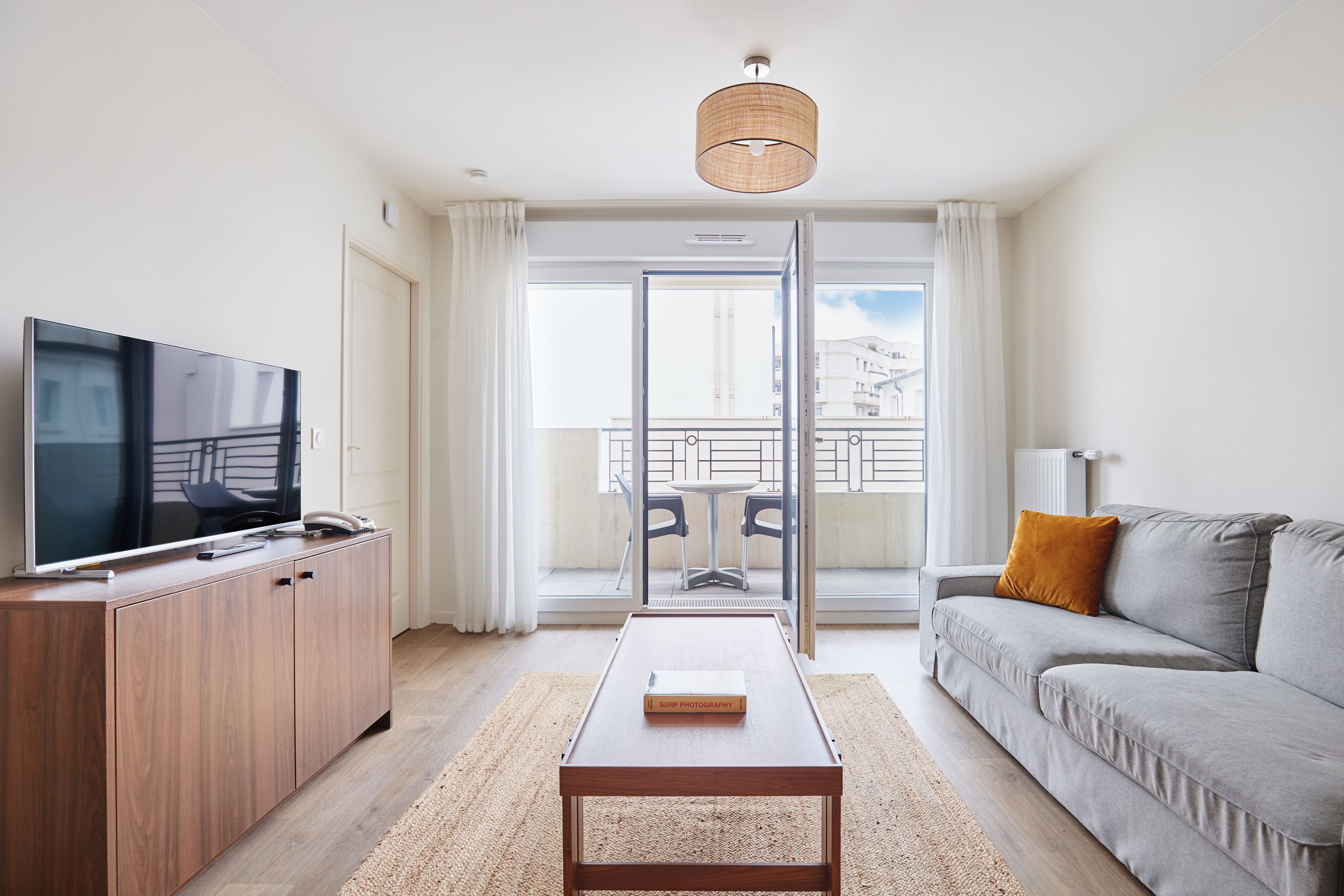 image Spacious living area with TV and access to a private balcony for fresh air and relaxation (please note: some units may not include a balcony).
