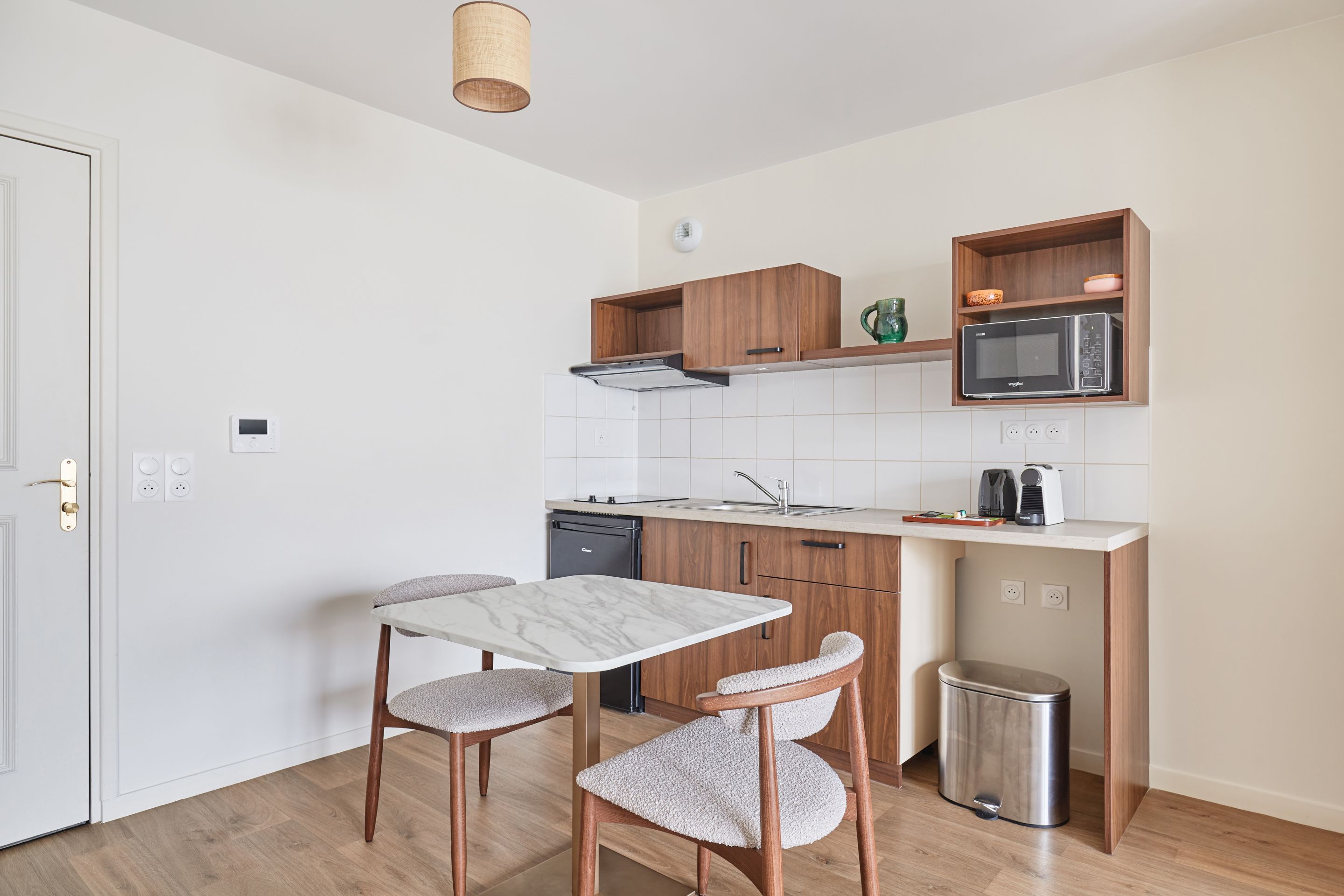 image Modern kitchenette featuring induction hobs, microwave, fridge, kettle, coffee maker, and extractor—everything you need for a comfortable stay.