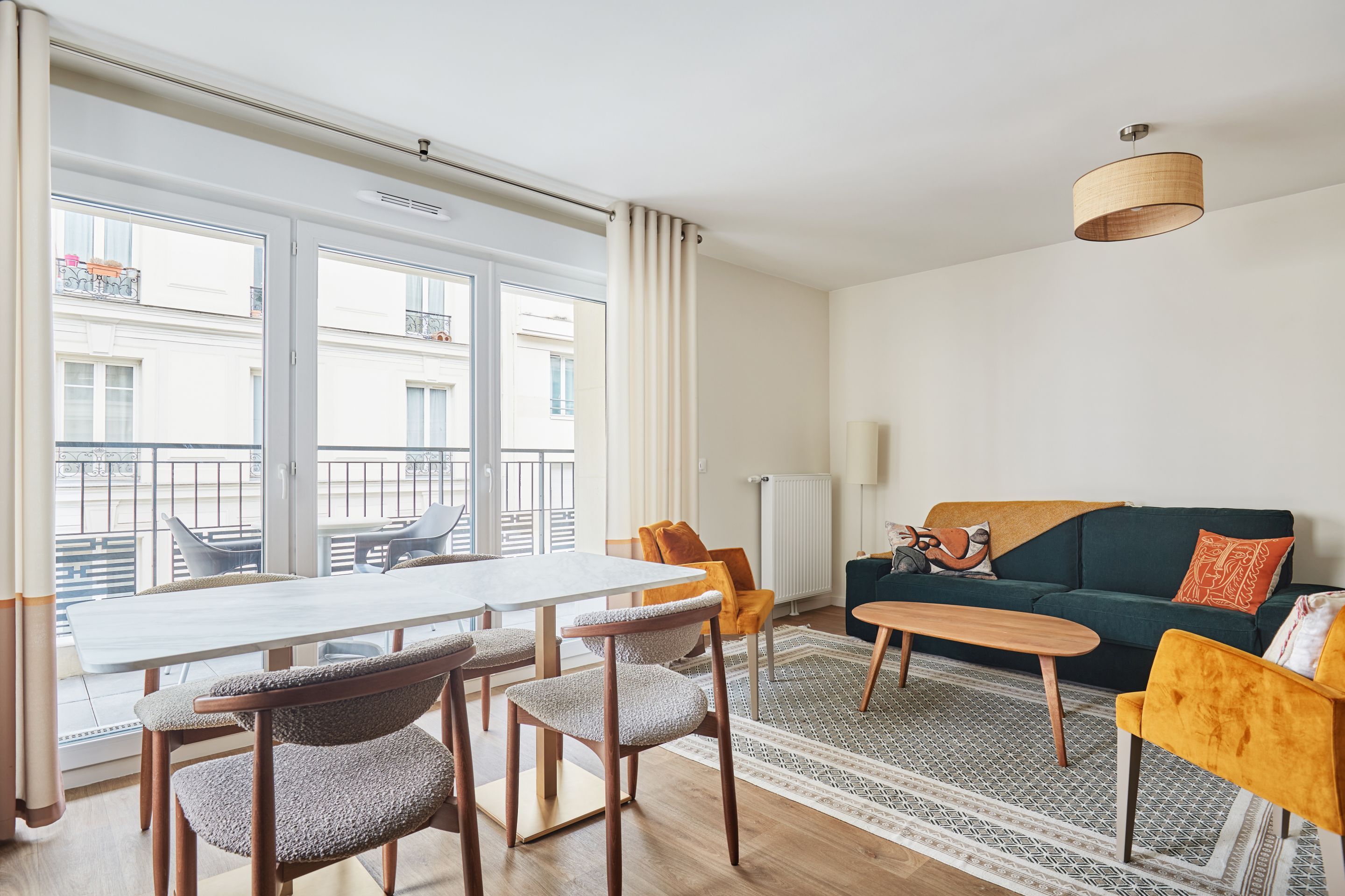 image Spacious and sunlit living room with modern seating and large windows—perfect for relaxing after a day in Paris.