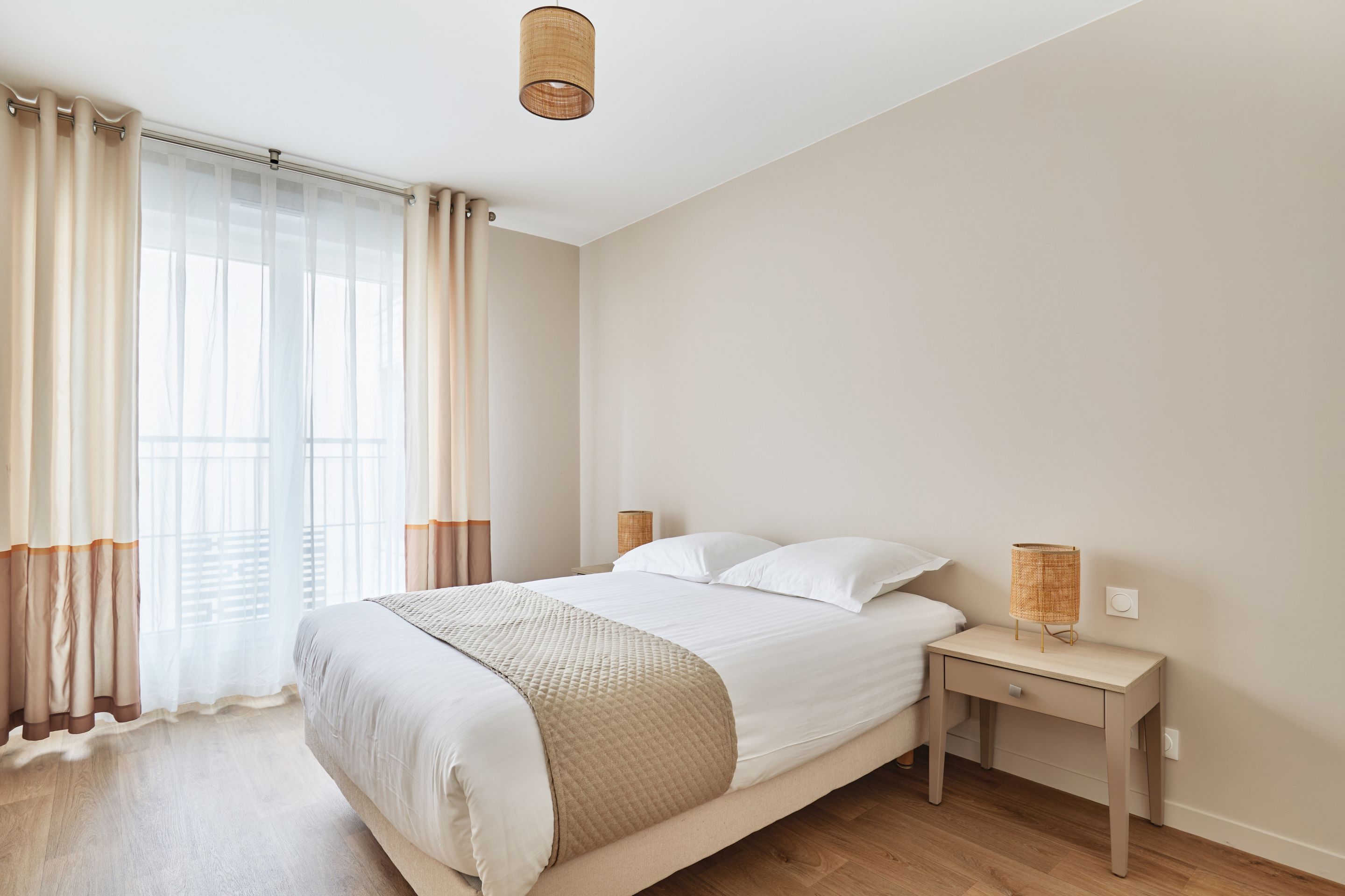image Primary bedroom featuring a plush double bed and sheer drapes, perfect for a peaceful night’s sleep.