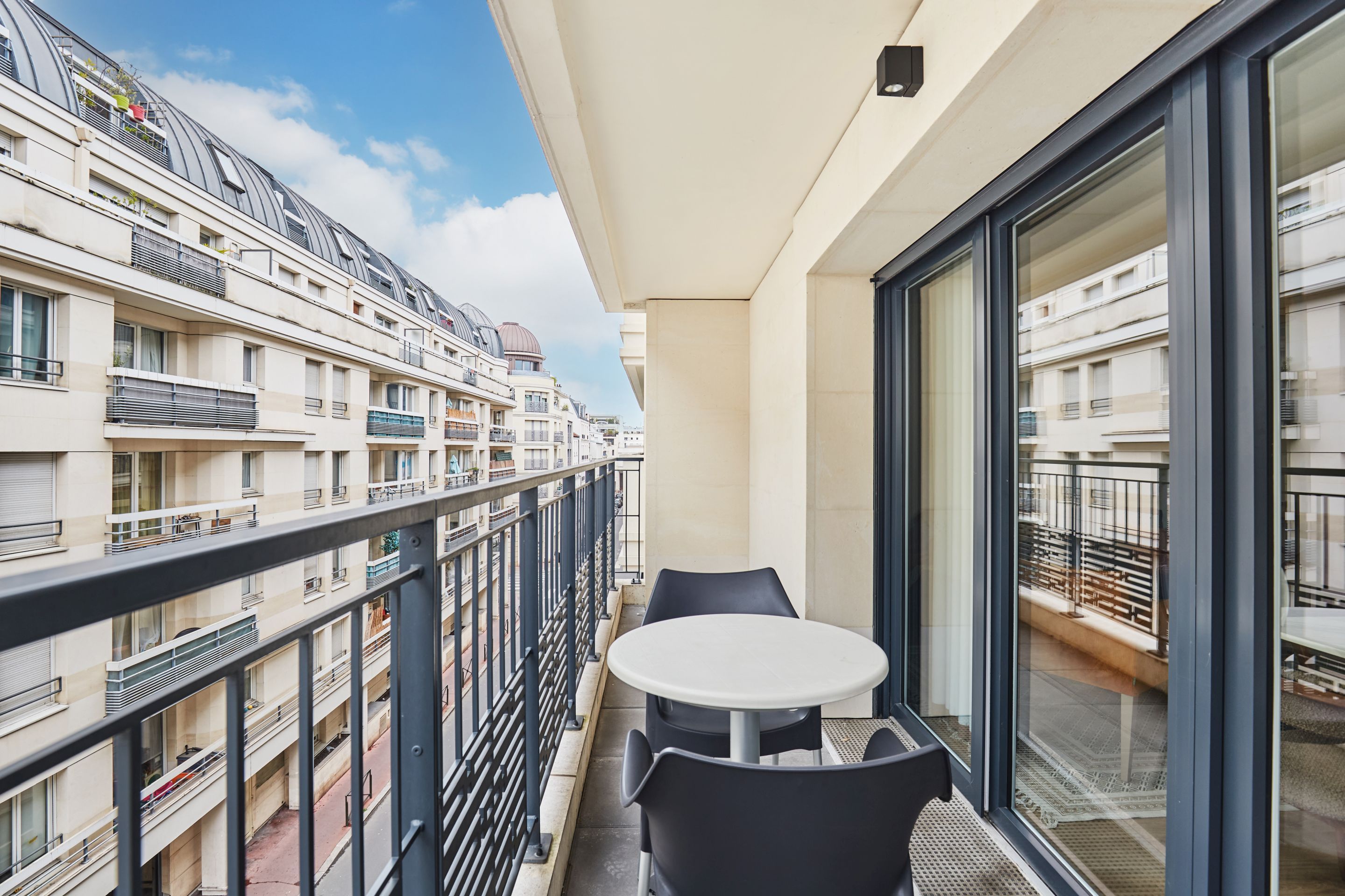 image Furnished balcony with rooftop views—enjoy open-air breakfasts or unwind at sunset with a drink.