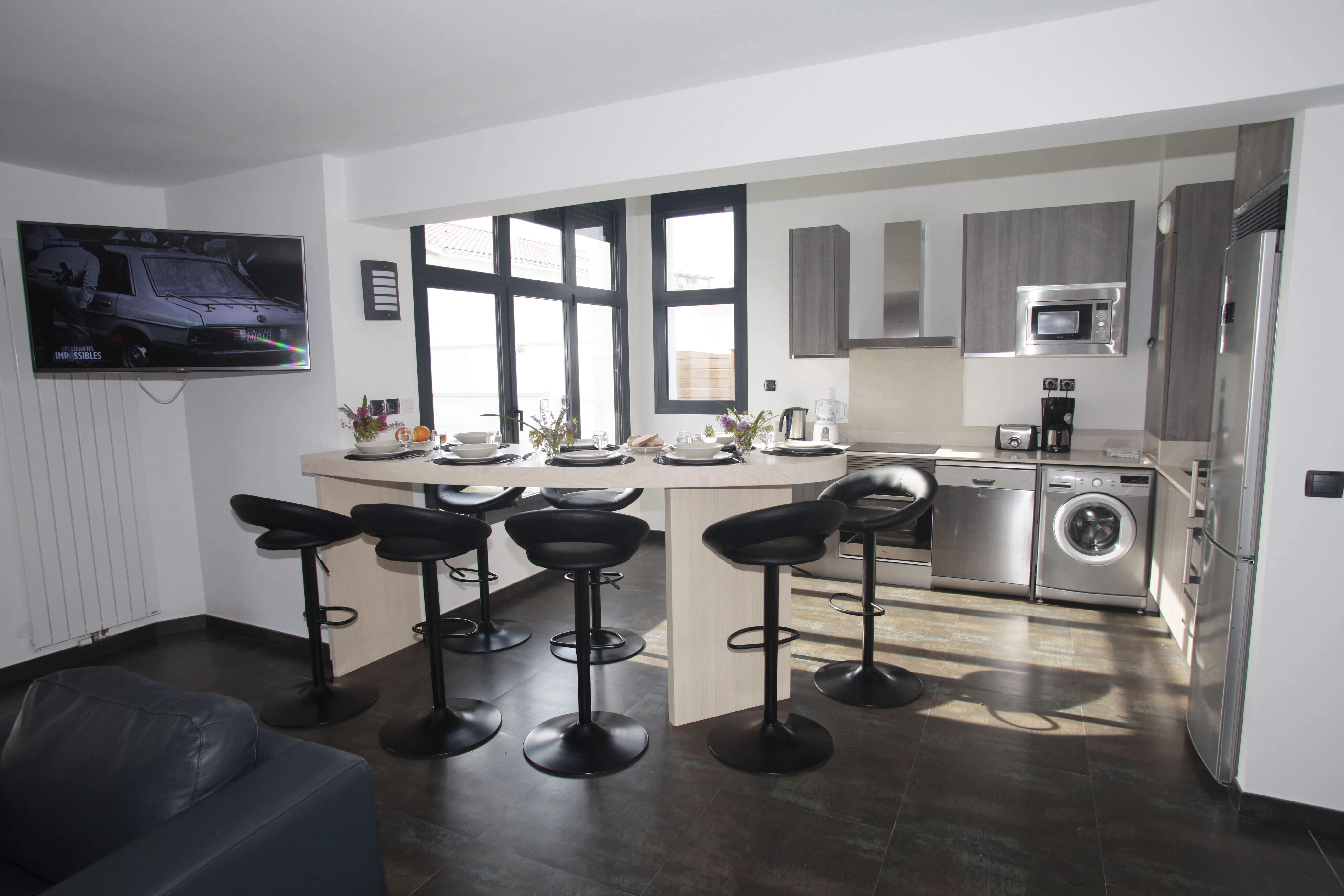 image Modern open-plan kitchen with bar seating, ideal for sharing meals or morning coffee with family.