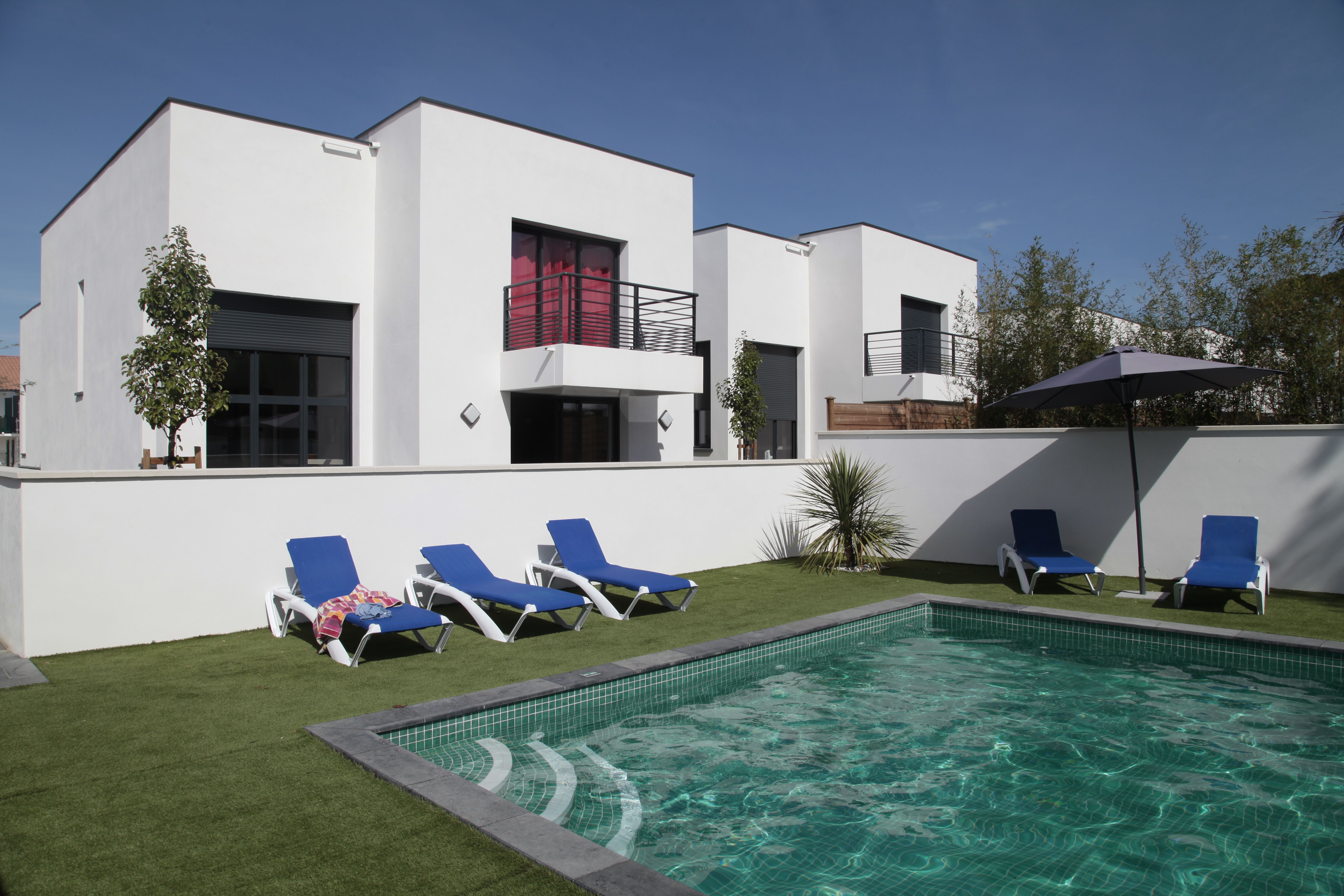 image Enjoy a refreshing dip in the heated outdoor pool, surrounded by private gardens and modern villas.