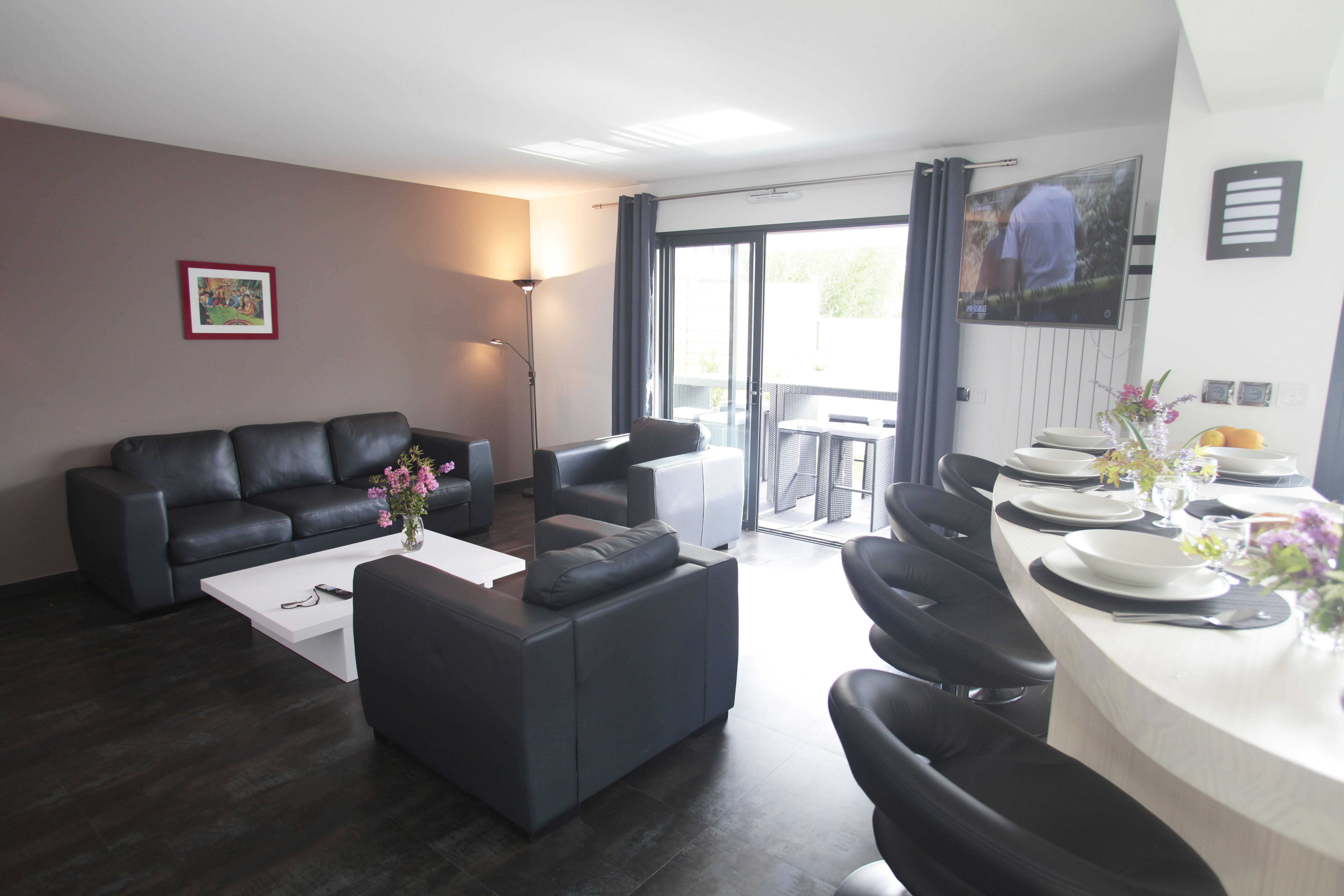 image Spacious and cozy living room with direct access to the terrace—perfect for relaxing after a beach day.