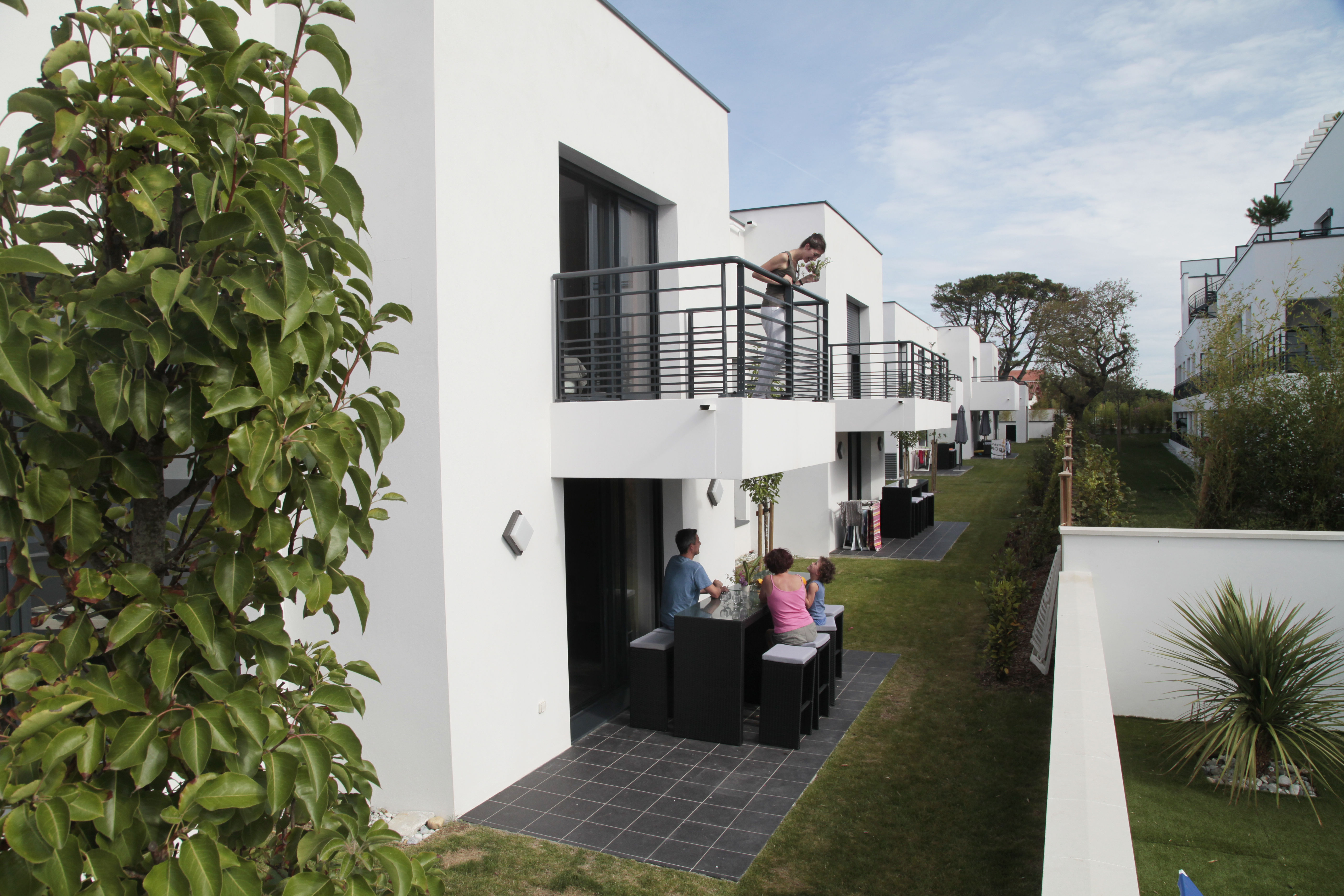 image Chic villa exterior with minimalist design, opening onto a private, furnished terrace—ideal for lounging or alfresco dining.