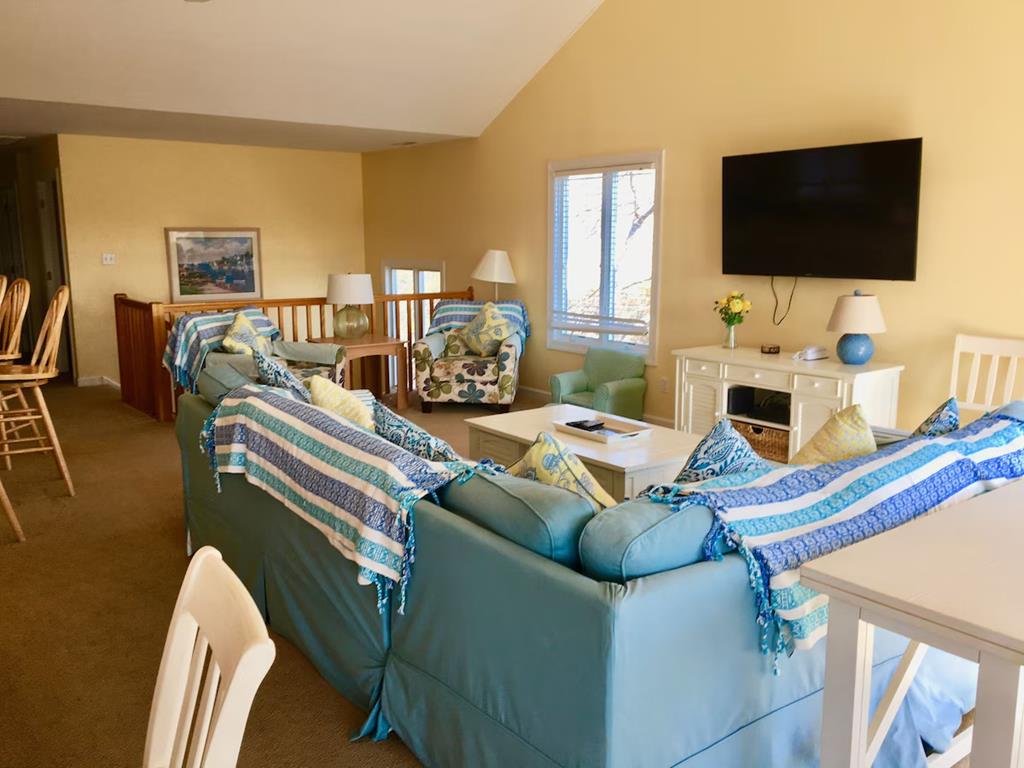 image The cozy living room offers comfortable seating with a large sectional and entertainment setup, ideal for family movie nights.