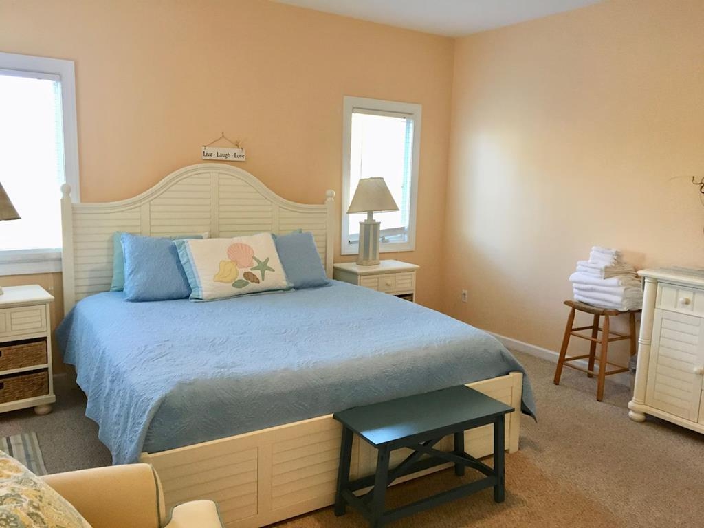 image This cozy bedroom features a queen-sized bed adorned with calming blue decor, perfect for restful beachside nights.