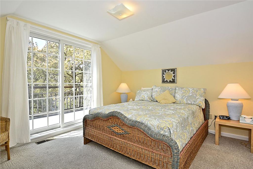 image The upstairs bedroom is filled with natural light from large windows and features a king-sized bed, stylish decor, and a cozy atmosphere perfect for restful nights.