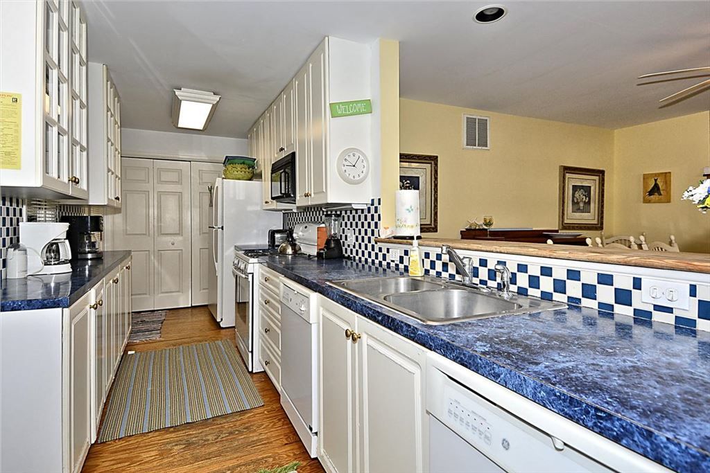 image The spacious kitchen features sleek blue countertops, ample cabinetry, and modern appliances, creating a welcoming space for meal preparation.