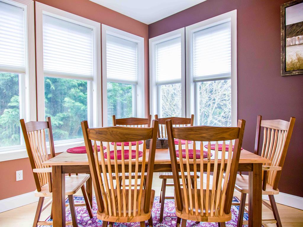 image Sunlit dining nook with wooden seating and wraparound windows—perfect for gathering over meals with a view.