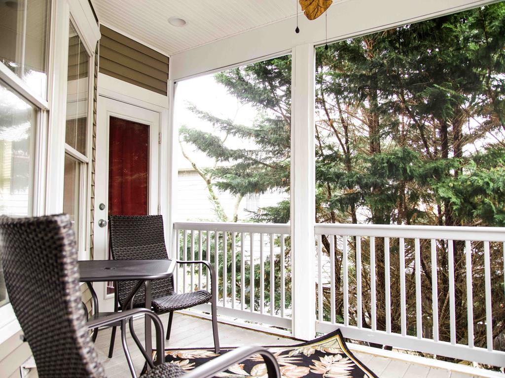 image Covered porch with cozy seating and ceiling fan—ideal for sipping coffee while enjoying the coastal breeze.