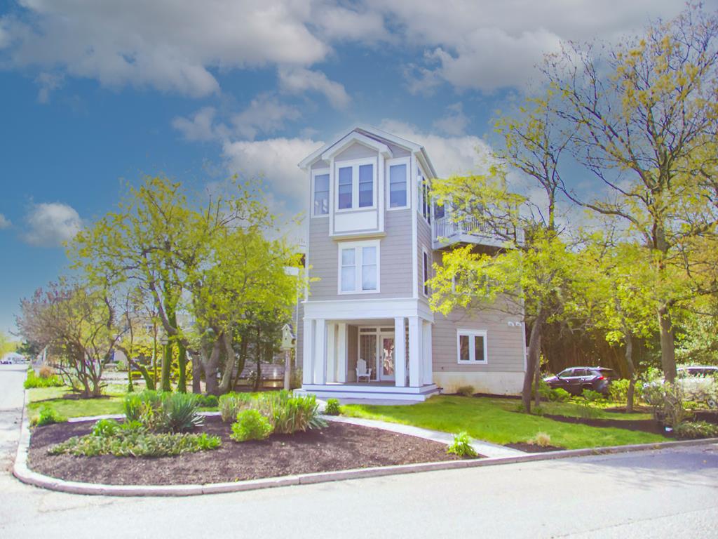 image This stunning 3-story beach house features a charming exterior with lush landscaping and a welcoming porch, perfect for enjoying the coastal breeze.