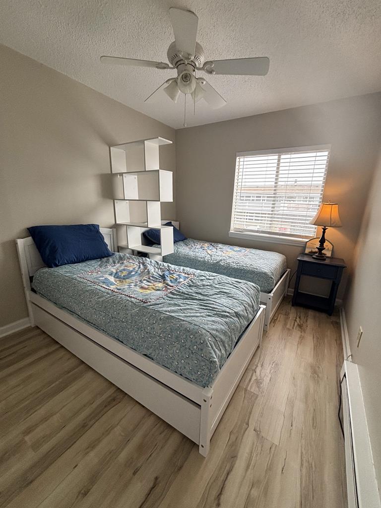 image This cheerful bedroom offers twin beds adorned with inviting bedding, natural light streaming through the window, and a ceiling fan for added comfort.