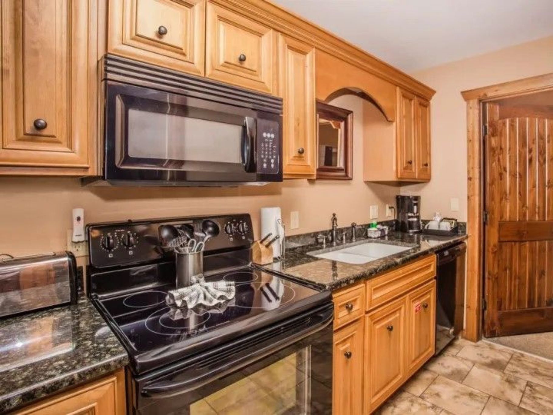 image Kitchen with black appliances, wooden cabinets, and ample counter space.