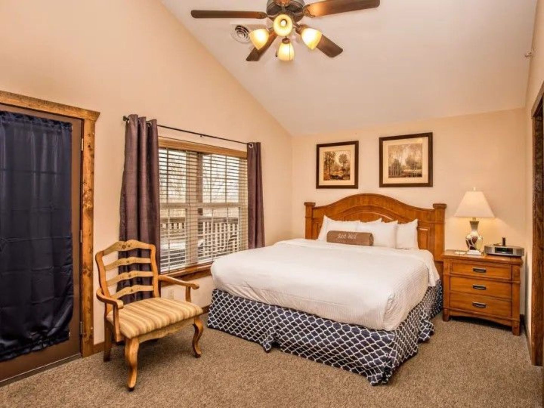 image Bedroom with queen bed, vaulted ceiling, and soft natural lighting from large windows.