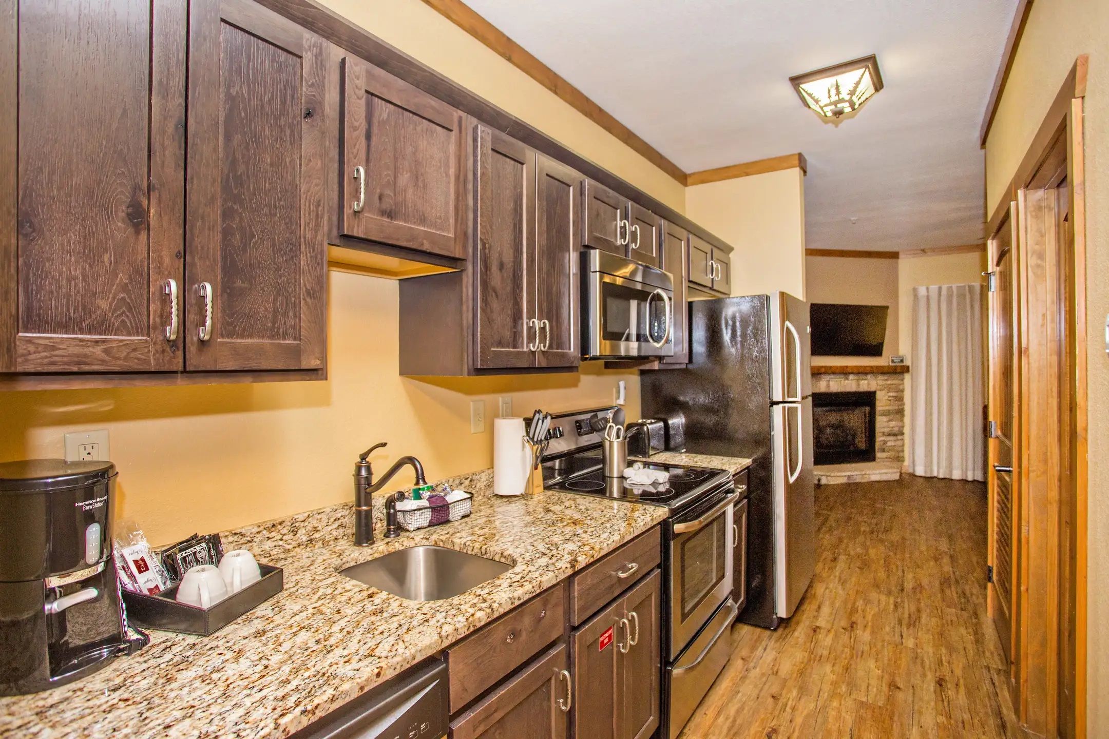 image Fully equipped kitchen with microwave, stove, and refrigerator.