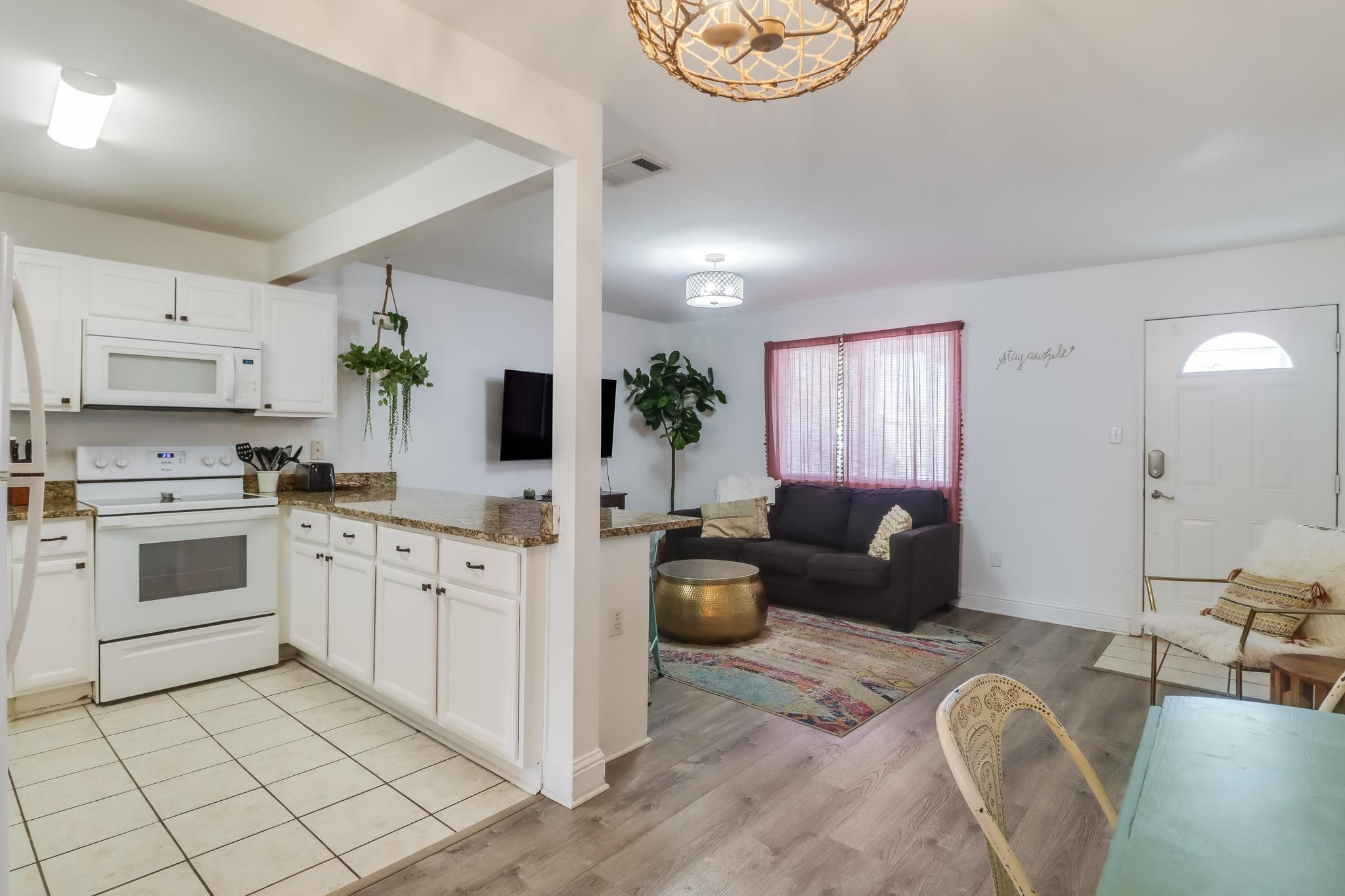 image This cozy one-bedroom condo features a bright living space with a modern kitchen, a comfortable couch, and a welcoming entrance.