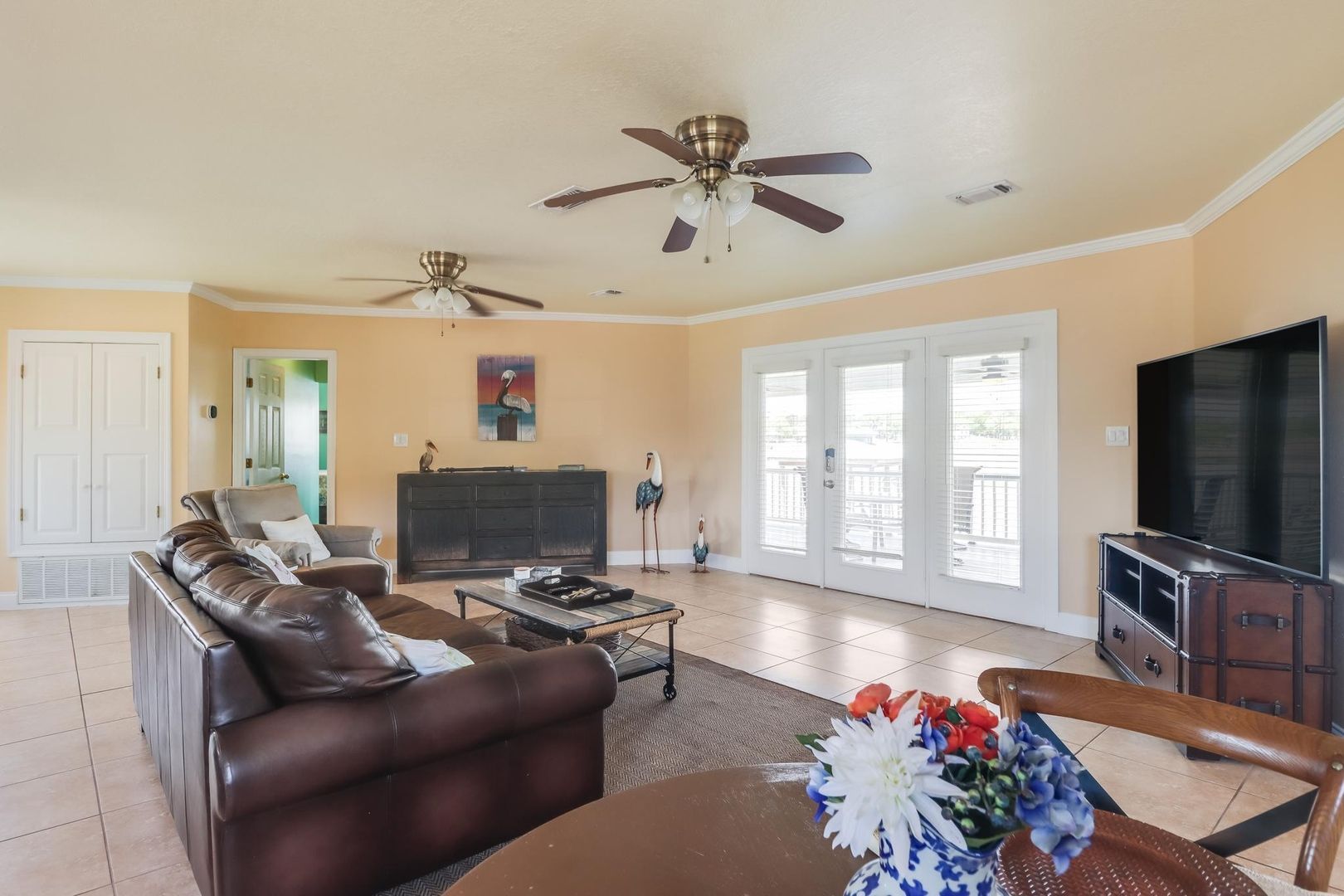 image Stylishly decorated, the spacious living area features beach-inspired accents and ample seating, leading to the waterfront deck.