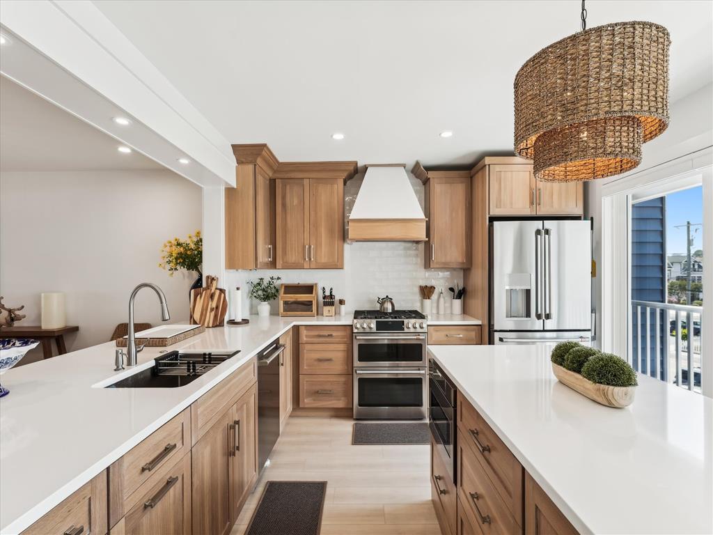 image Cook in style in the fully renovated kitchen featuring a spacious island, sleek new appliances, and warm wood cabinetry.