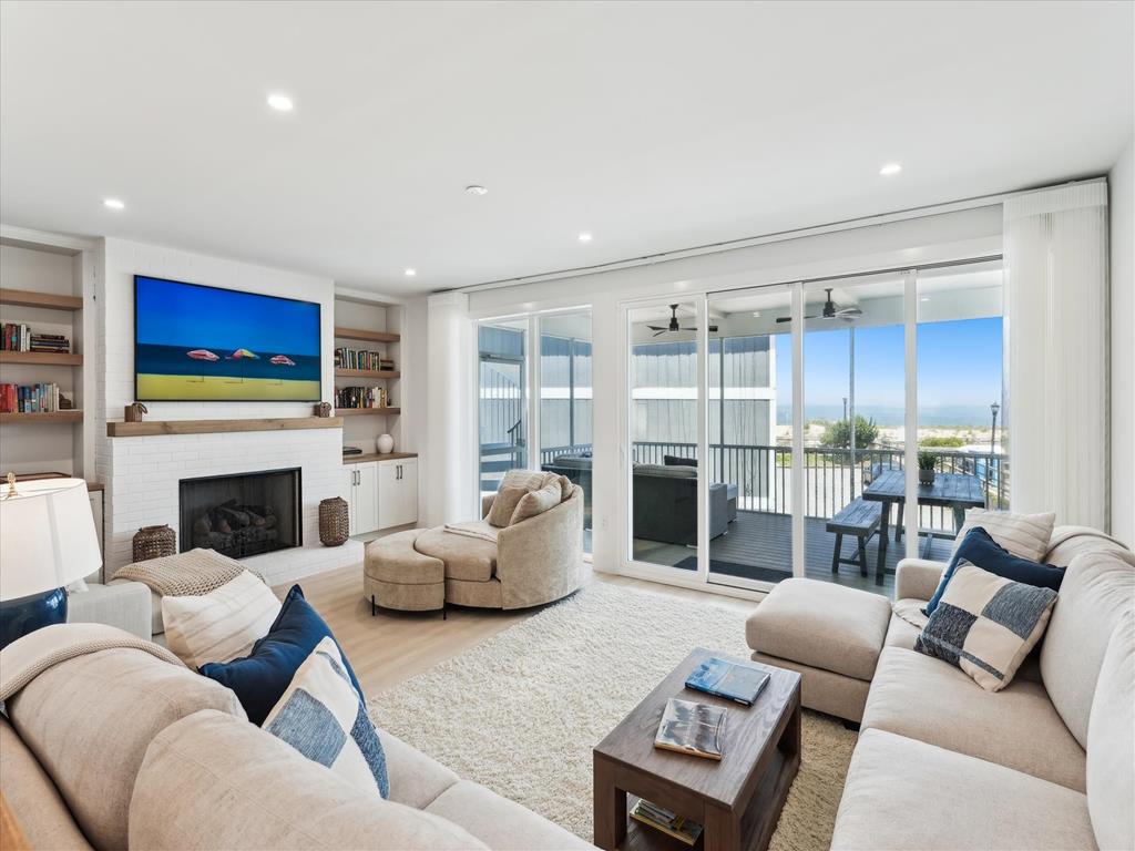 image The cozy living room, adorned with plush seating and a sleek fireplace, offers breathtaking ocean views through expansive sliding doors, inviting relaxation and coastal charm.