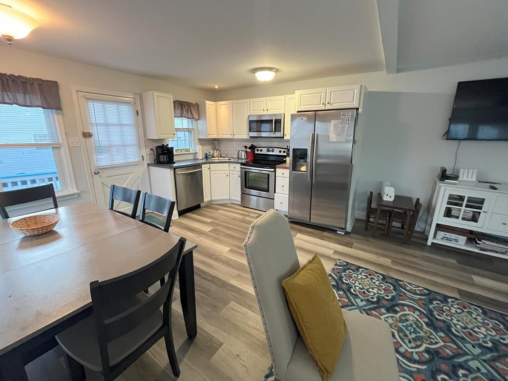image Fully equipped kitchen featuring modern appliances, ample counter space, and a dining area for family meals.