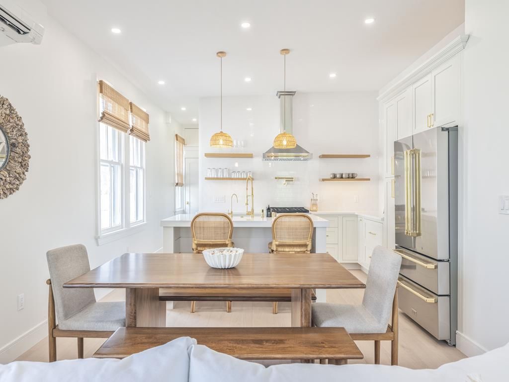 image Dining room with woven pendant lights, wooden table, and ample seating for group meals.