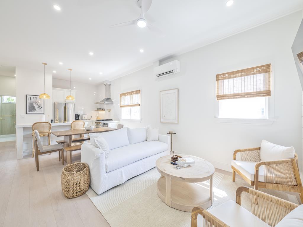 image Open-concept living and dining area with crisp white palette and coastal flair.