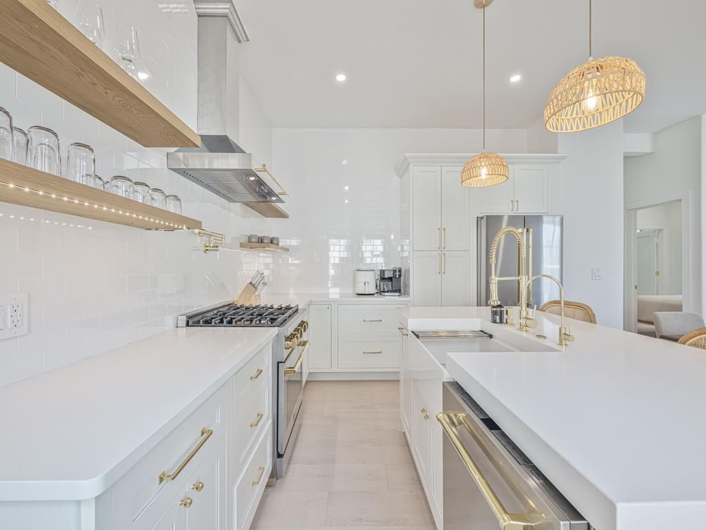 image Fully equipped kitchen with high-end appliances and sleek white finishes.