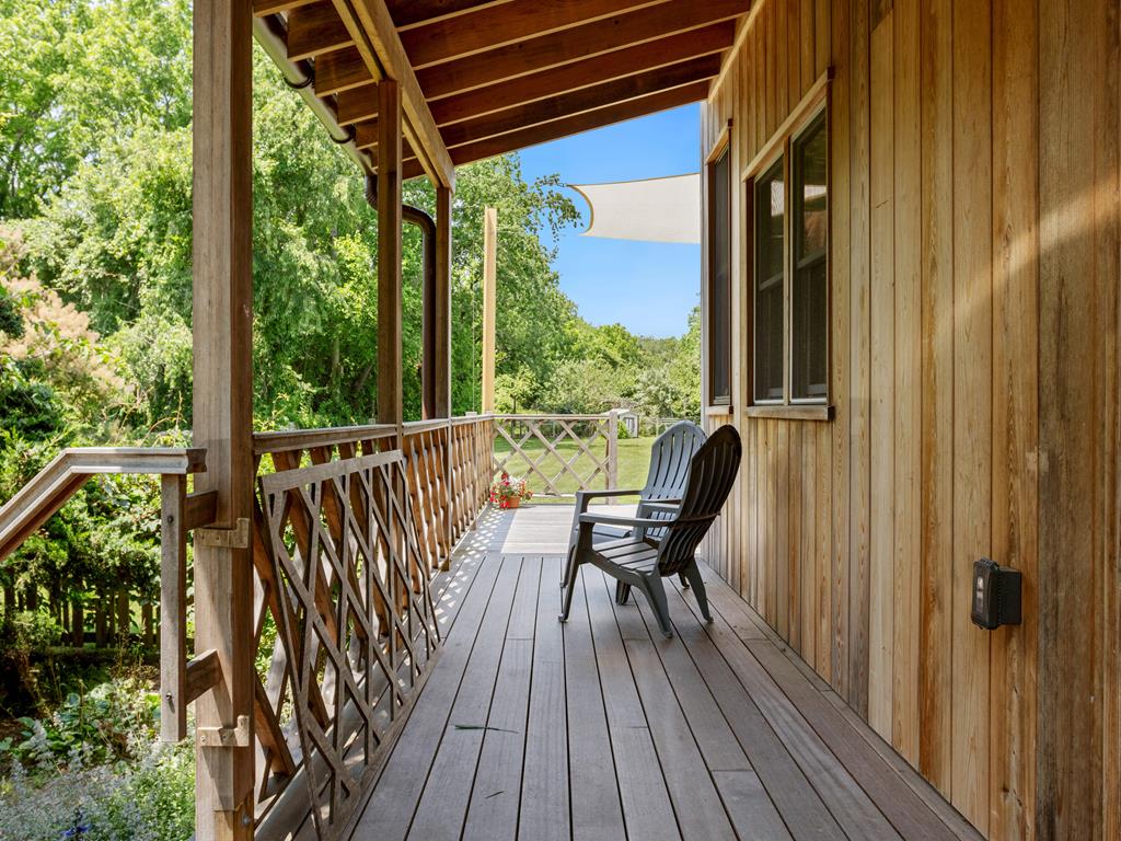 image A peaceful porch with rocking chairs, providing a perfect spot to relax and enjoy the serene surroundings of the farmhouse.