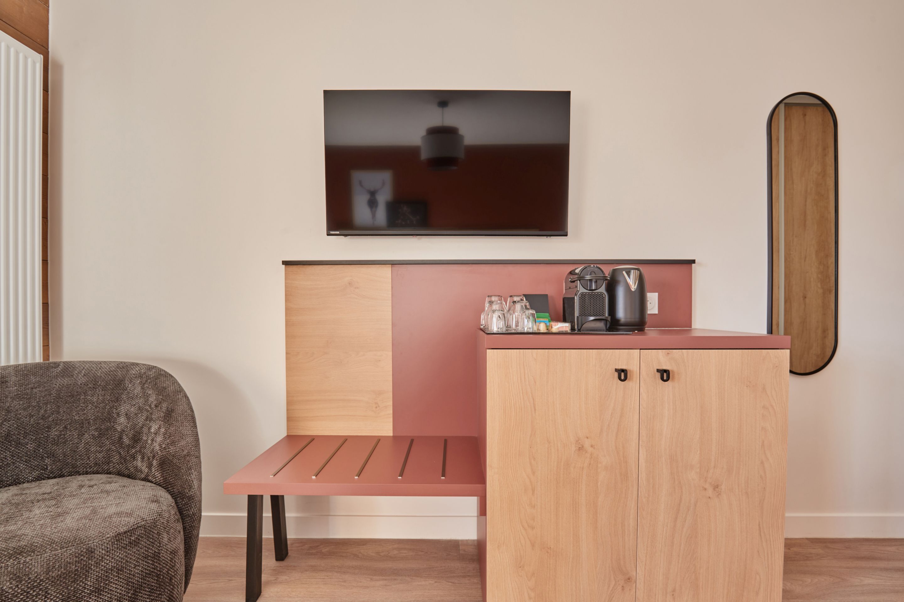 image Wall-mounted TV, coffee machine, and glassware on a fitted unit — everything you need for a relaxed evening in.