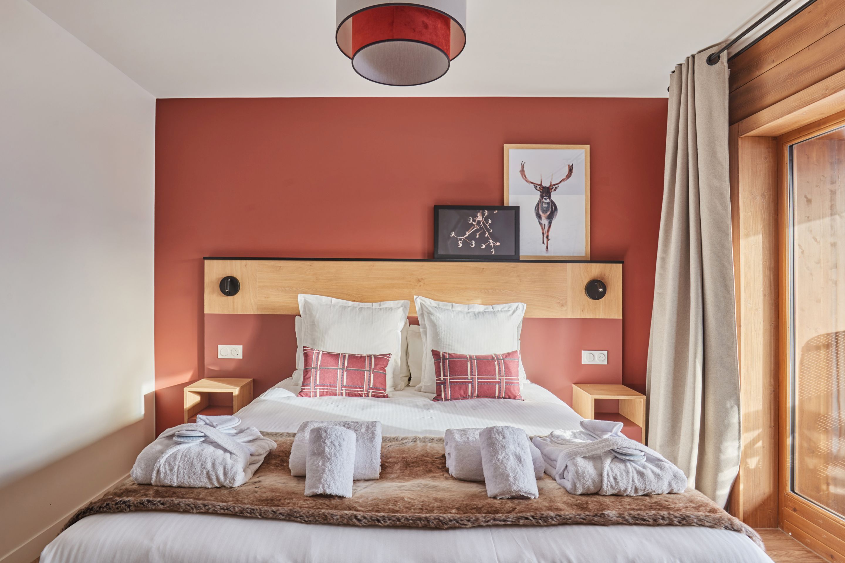 image Natural light fills the bedroom through the balcony window — step outside for fresh alpine air after a day on the slopes.