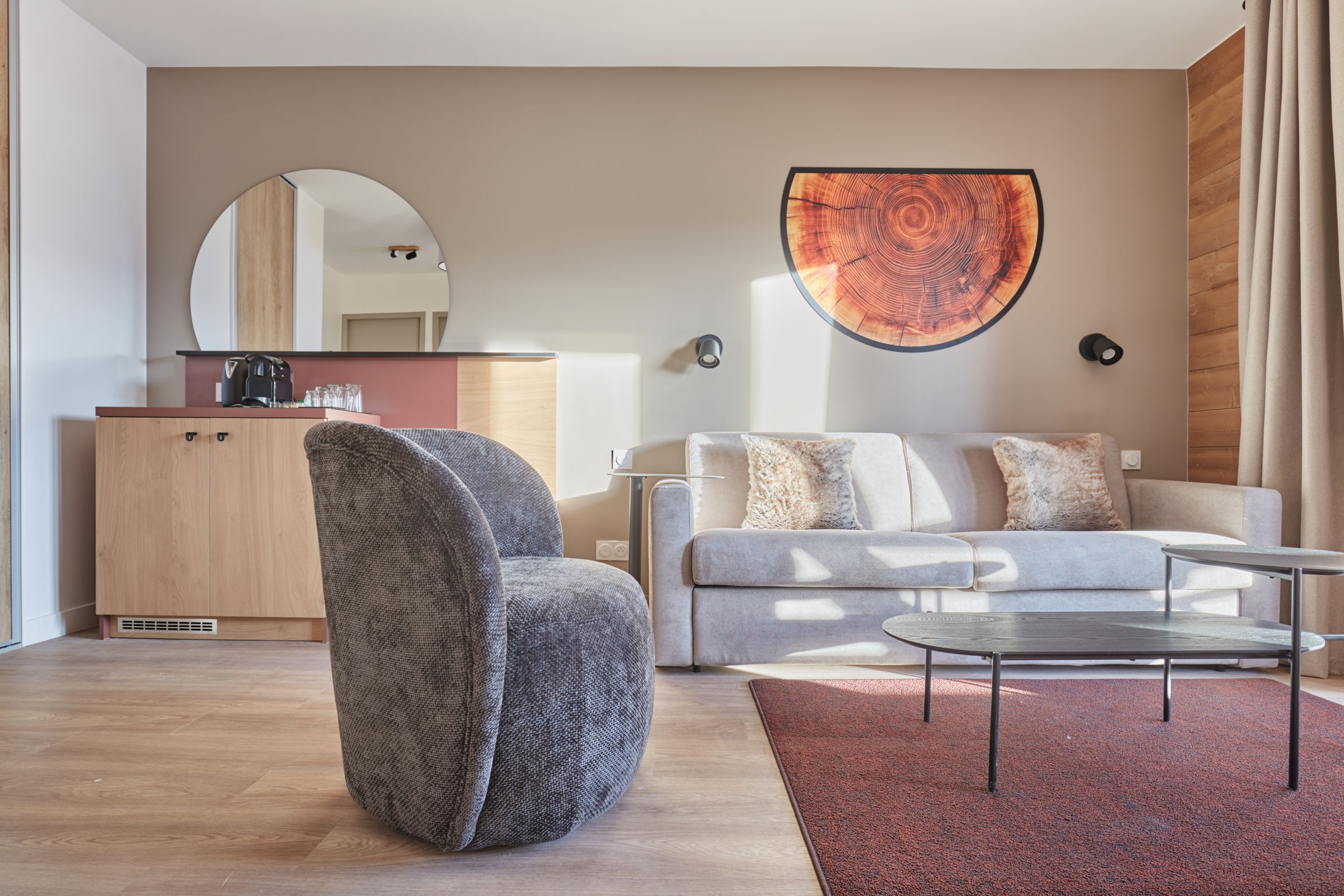 image Living area with a grey sofa, armchair, and coffee table — the sofa converts to a double bed for additional guests.