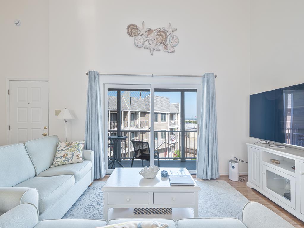image Bright and breezy lounge space featuring beachy decor and direct access to the balcony.
