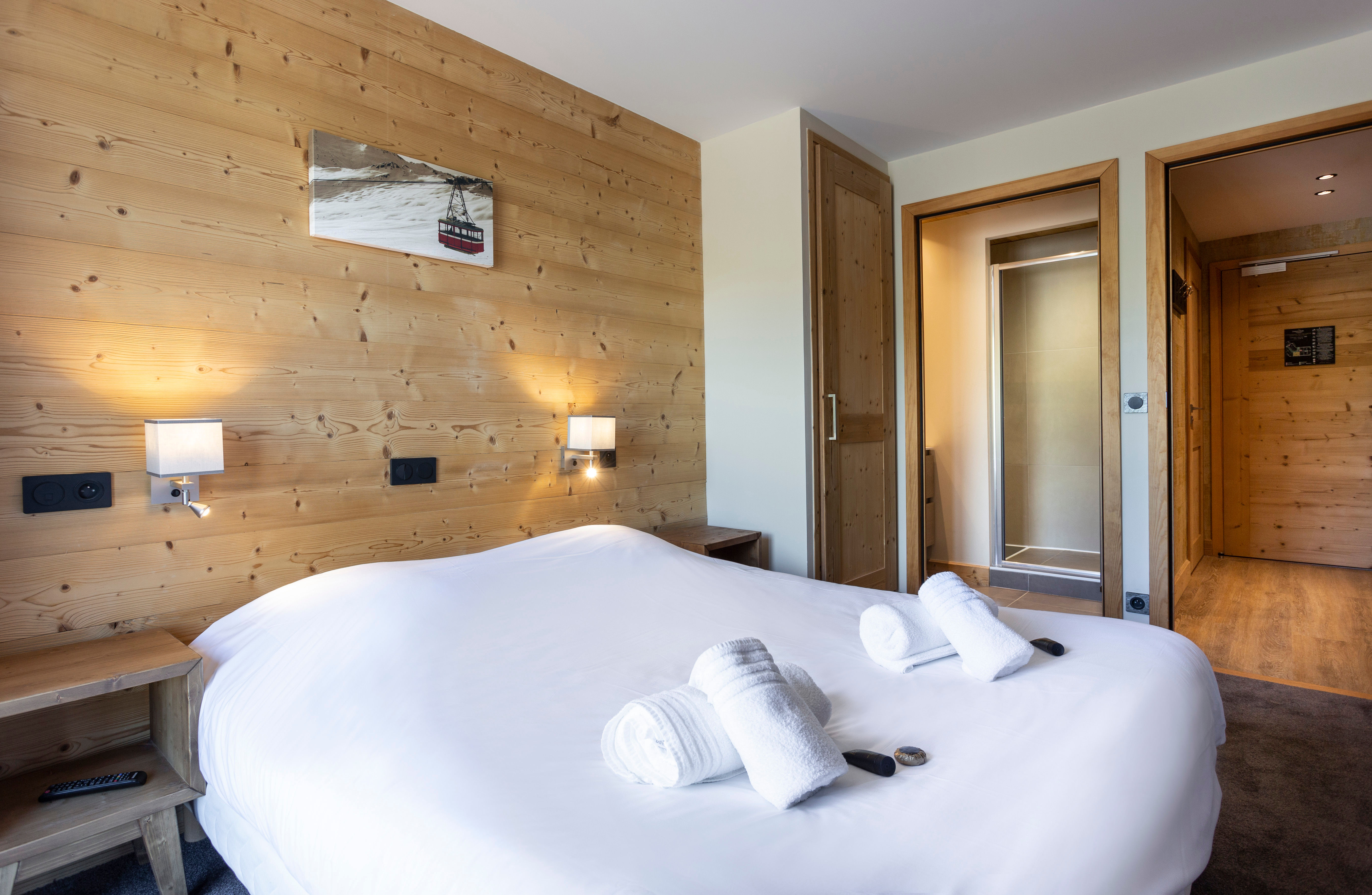 image The cozy double bedroom offers a serene retreat with soft linens, warm wood elements, and an en-suite bathroom for ultimate convenience.