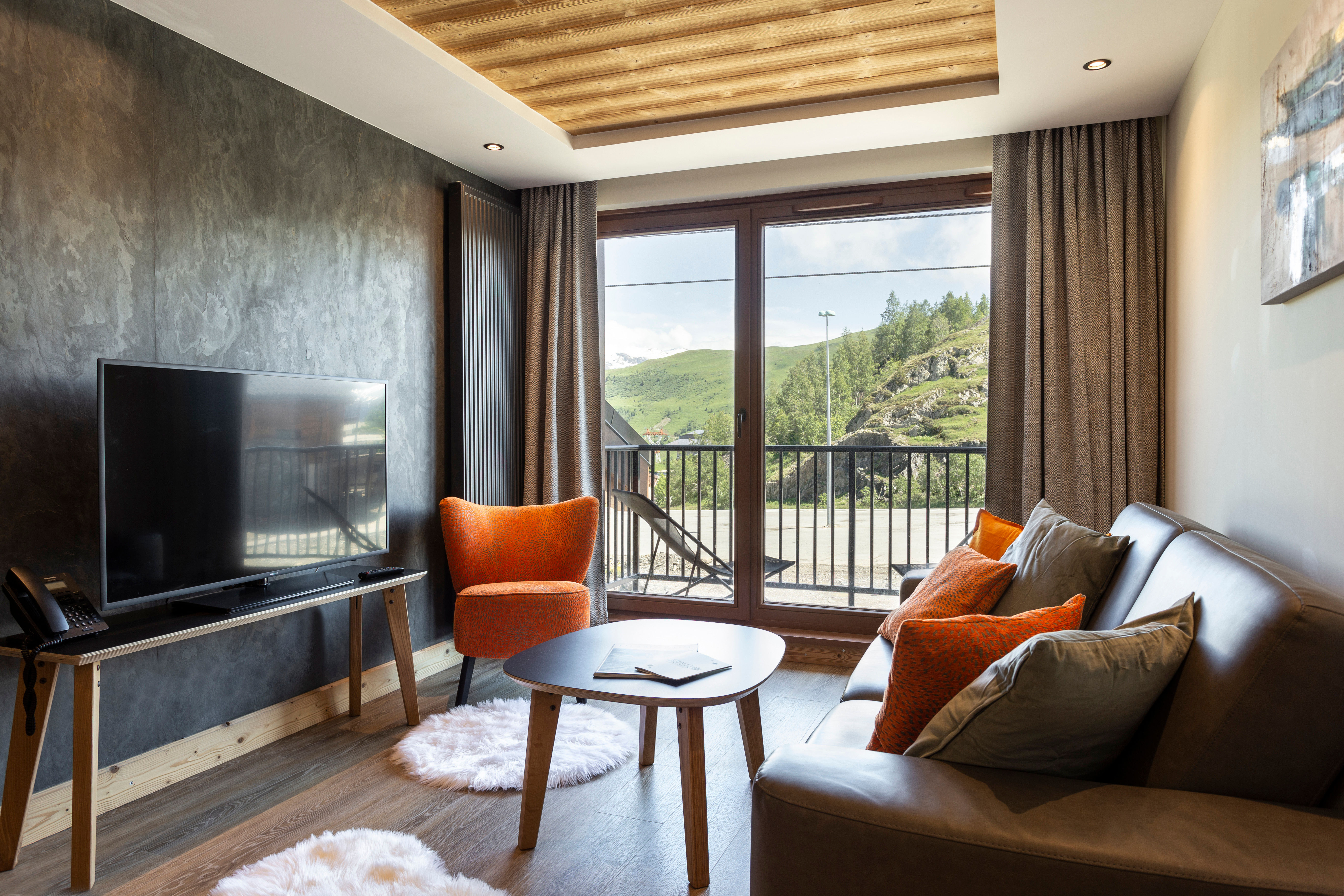 image The second living area boasts large windows that frame the picturesque mountain scenery, accented by contemporary furnishings and a comforting color palette.